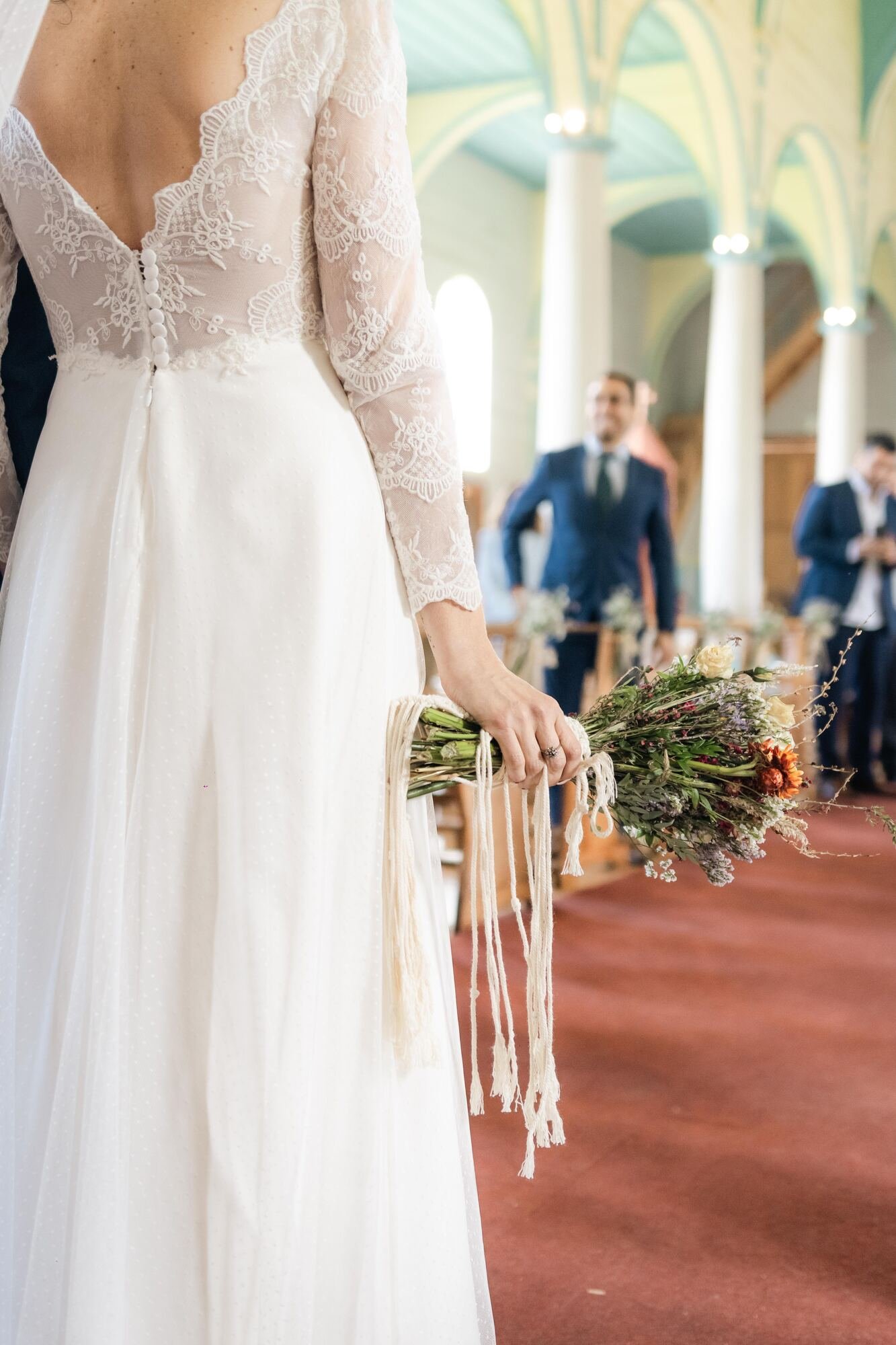 La novia de espaldas en el pasillo de la iglesia durante la ceremonia en Chiloé		