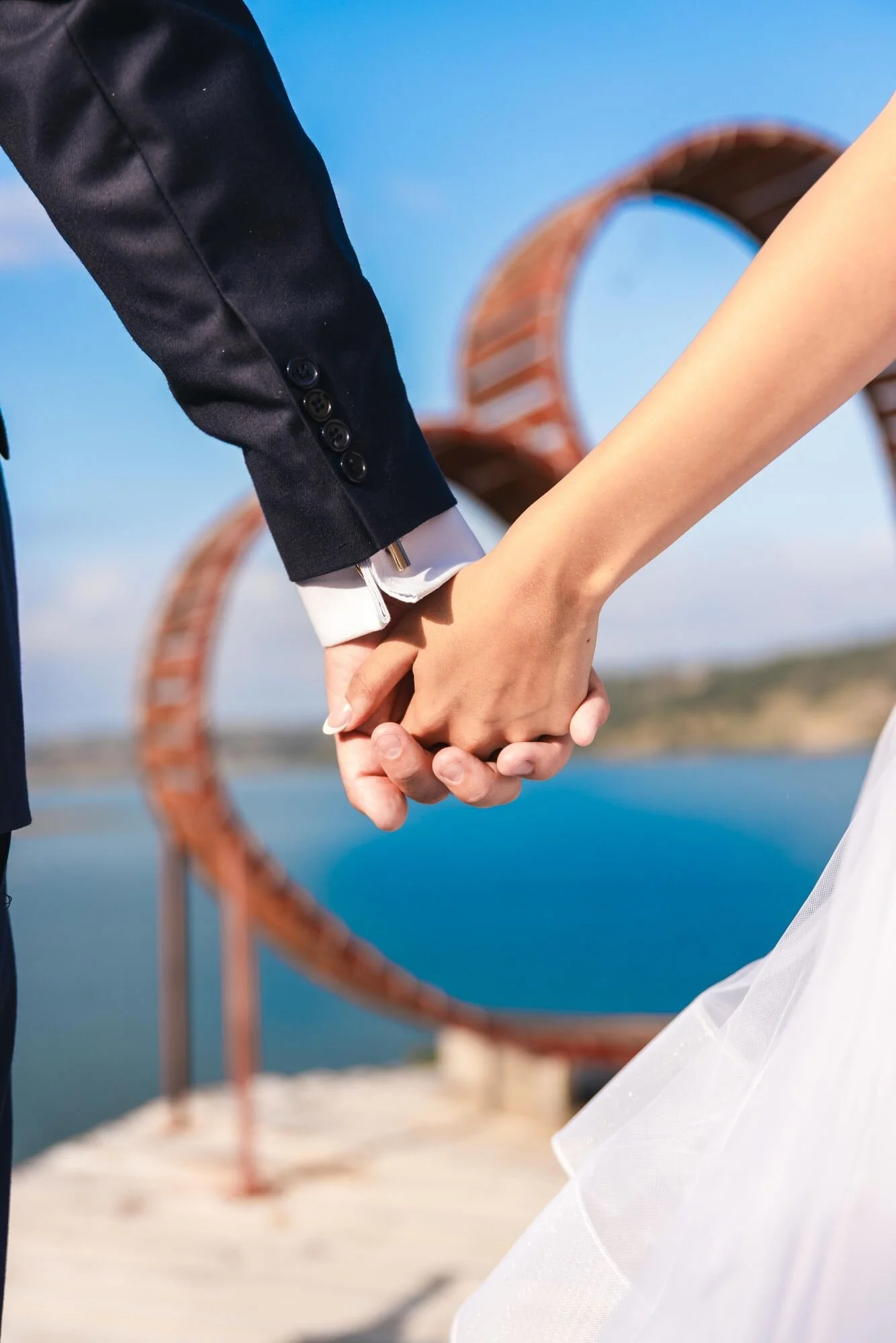 Los novios tomados de la mano frente al mar desde el mirador de Castro, Chiloé
