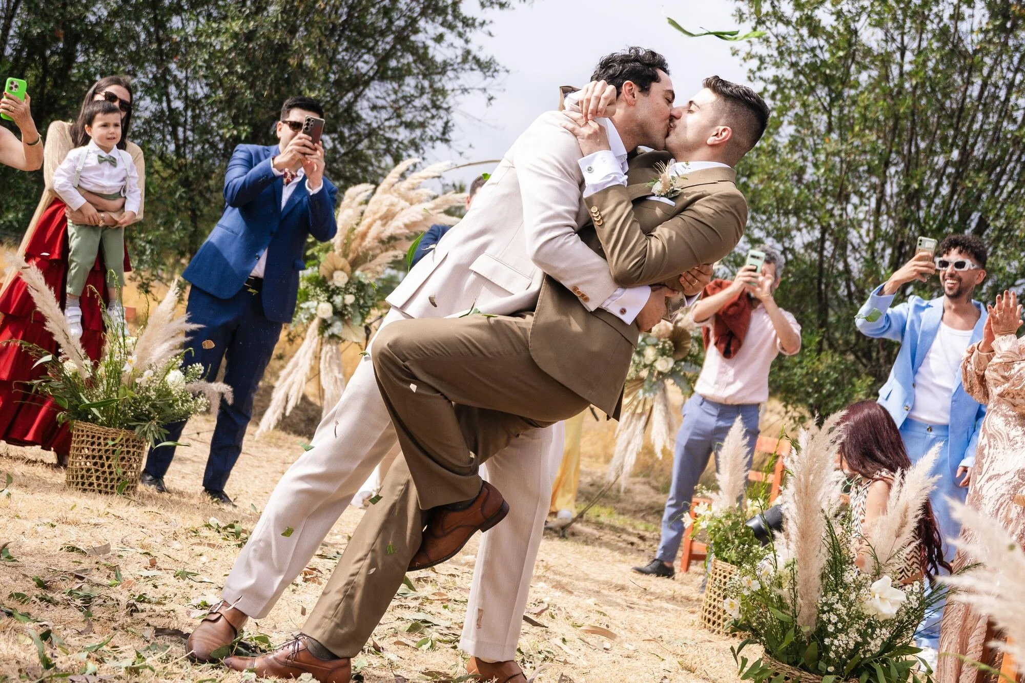 Beso de los novios rodeados de invitados al terminar la ceremonia en Ancud, Chiloé