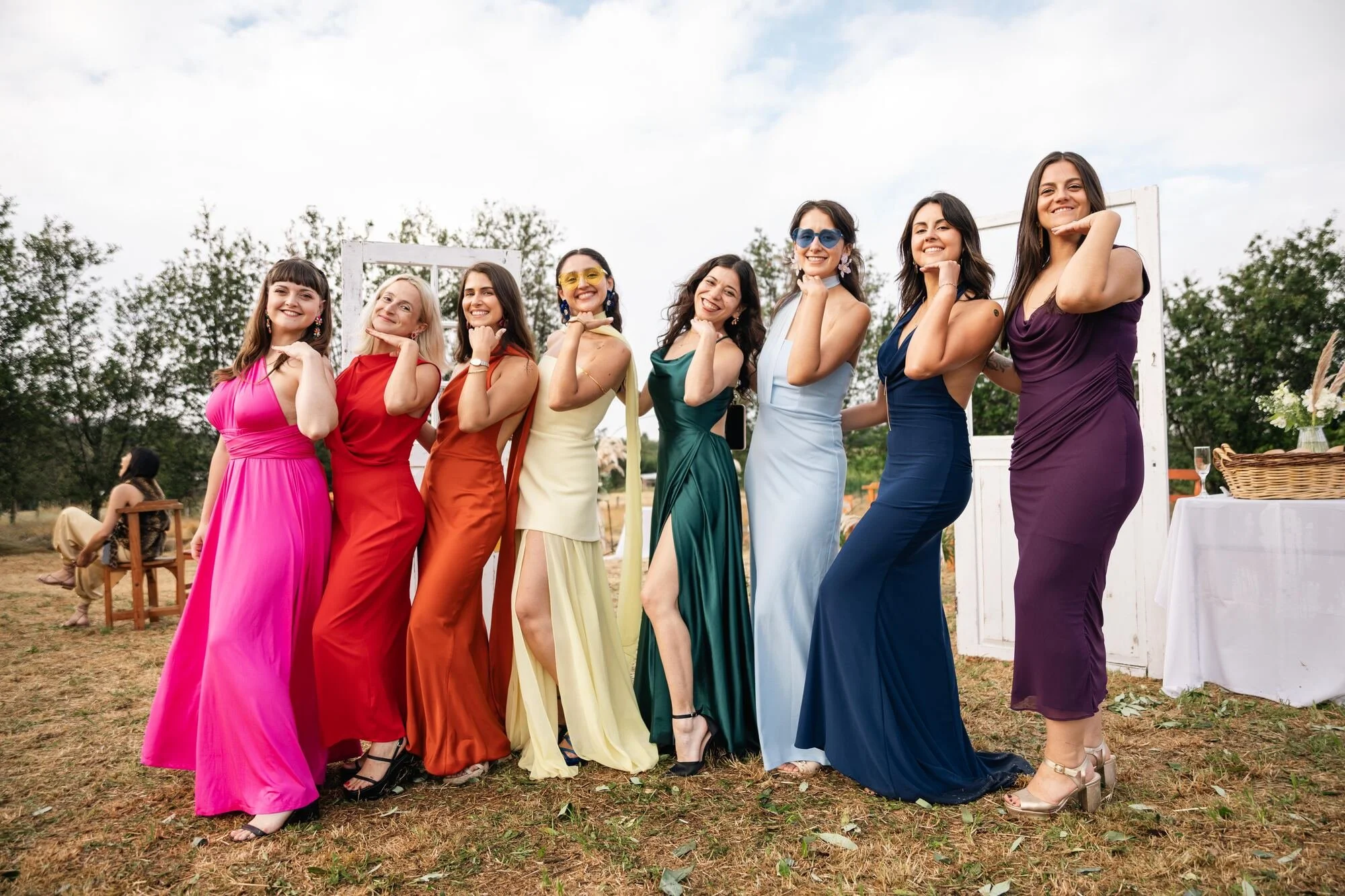 Damas de honor con vestidos largos de colores posando en el campo durante una boda en Ancud, Chiloé
