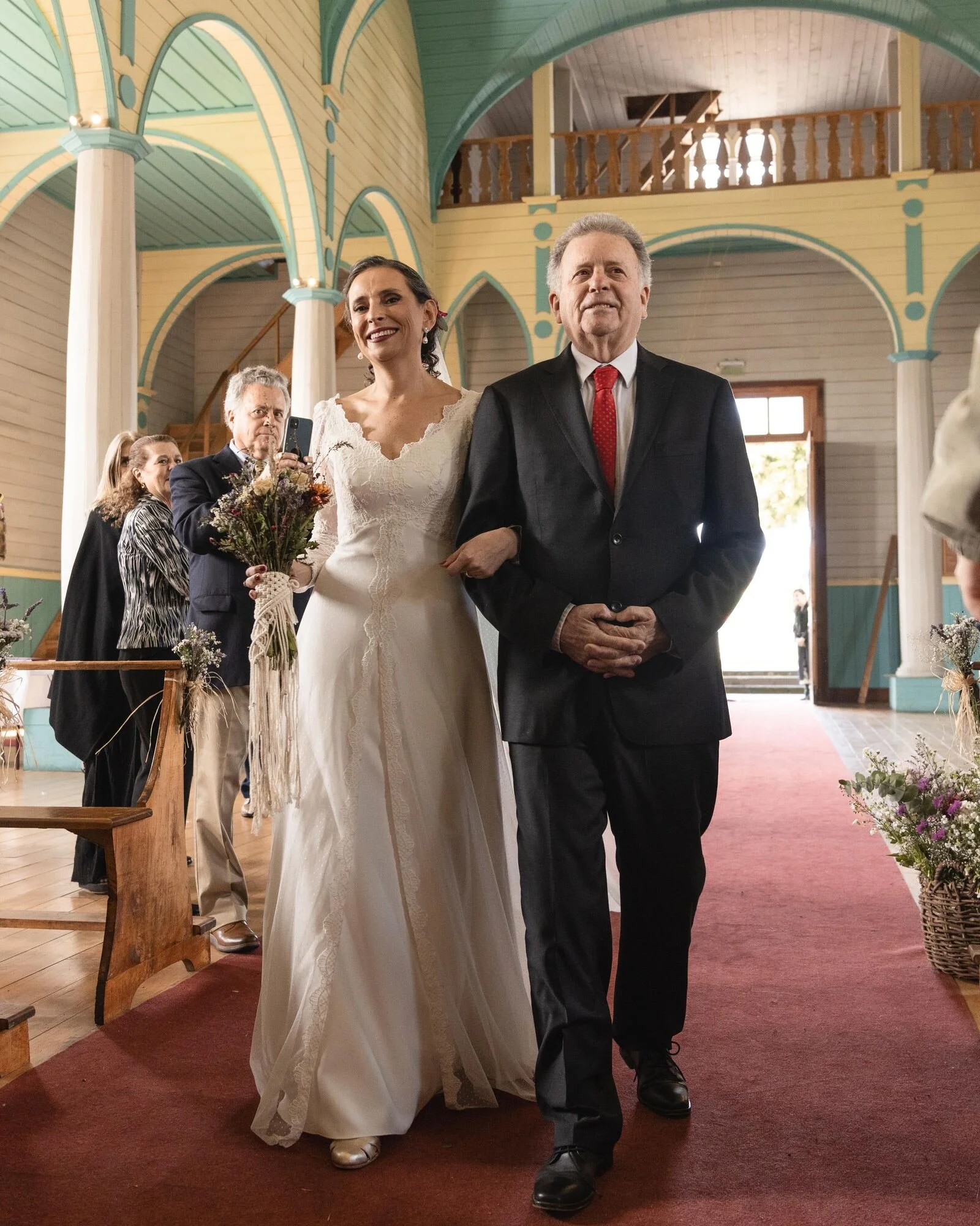 La novia entrando a la iglesia del brazo de su padre entre los invitados, Chiloé	