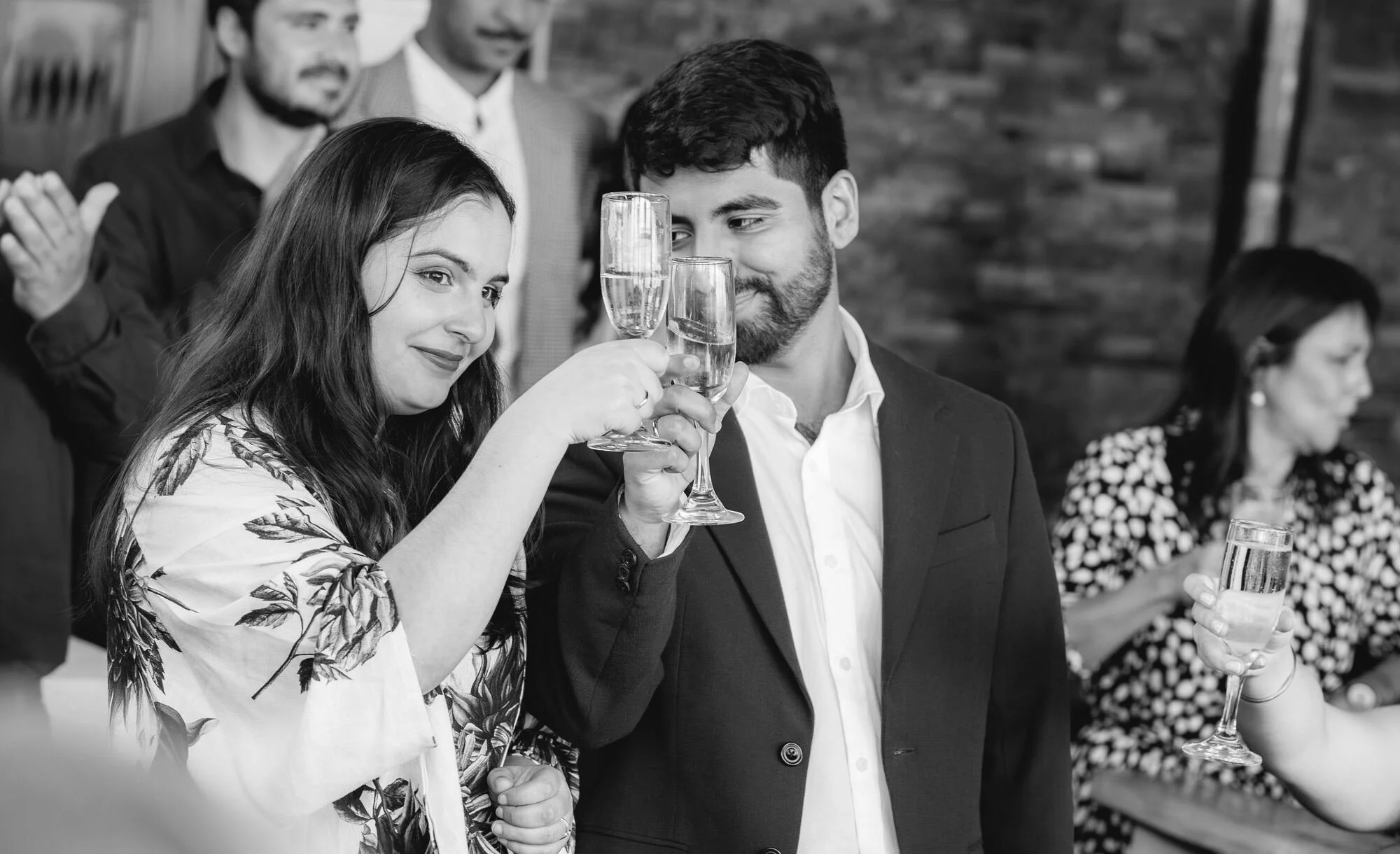 Invitados brindando, fotografía en blanco y negro de un matrimonio en Castro, Chiloé	