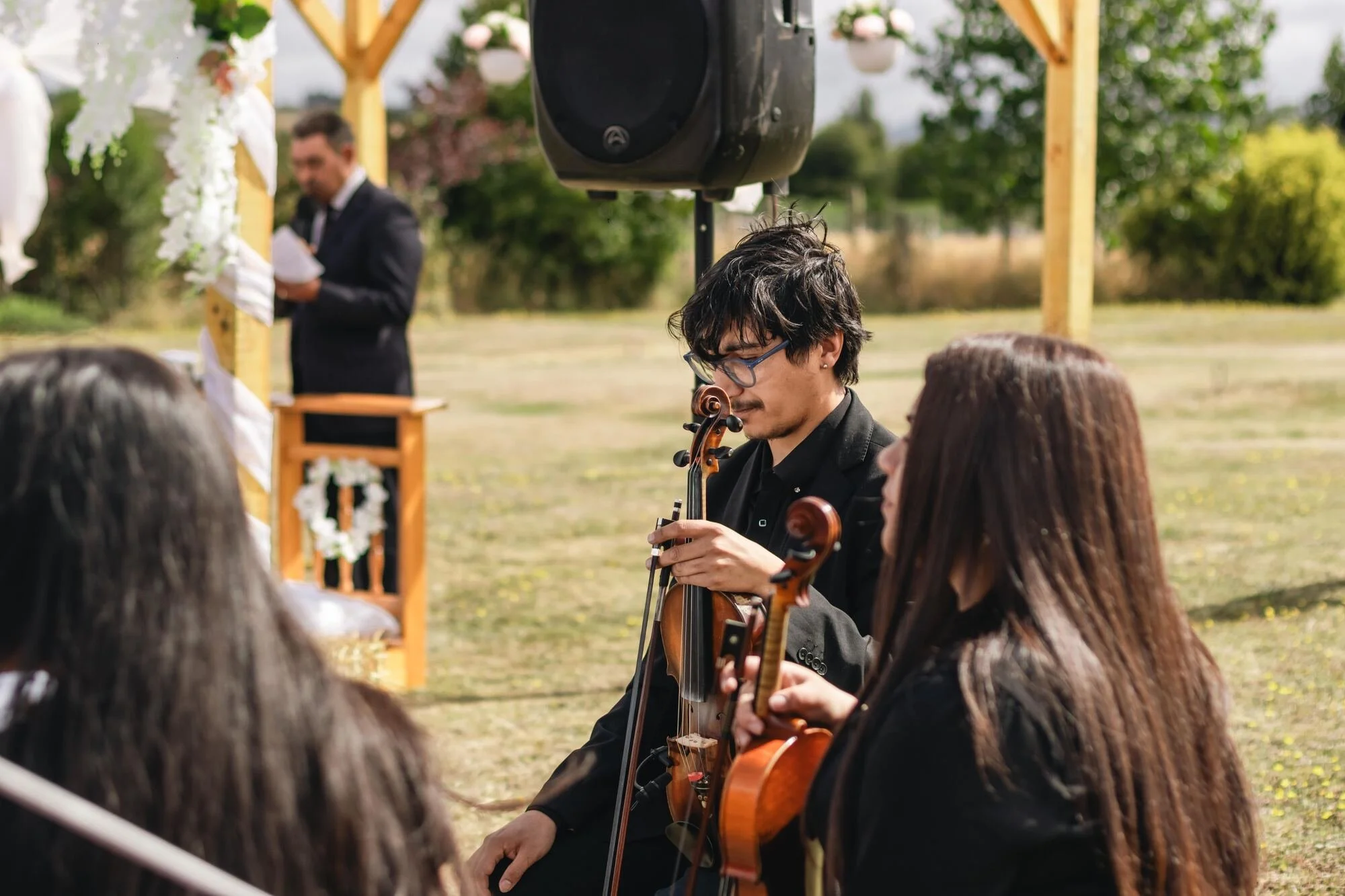 Cuarteto de cuerdas tocando durante la ceremonia al aire libre en Quilquico, Chiloé	