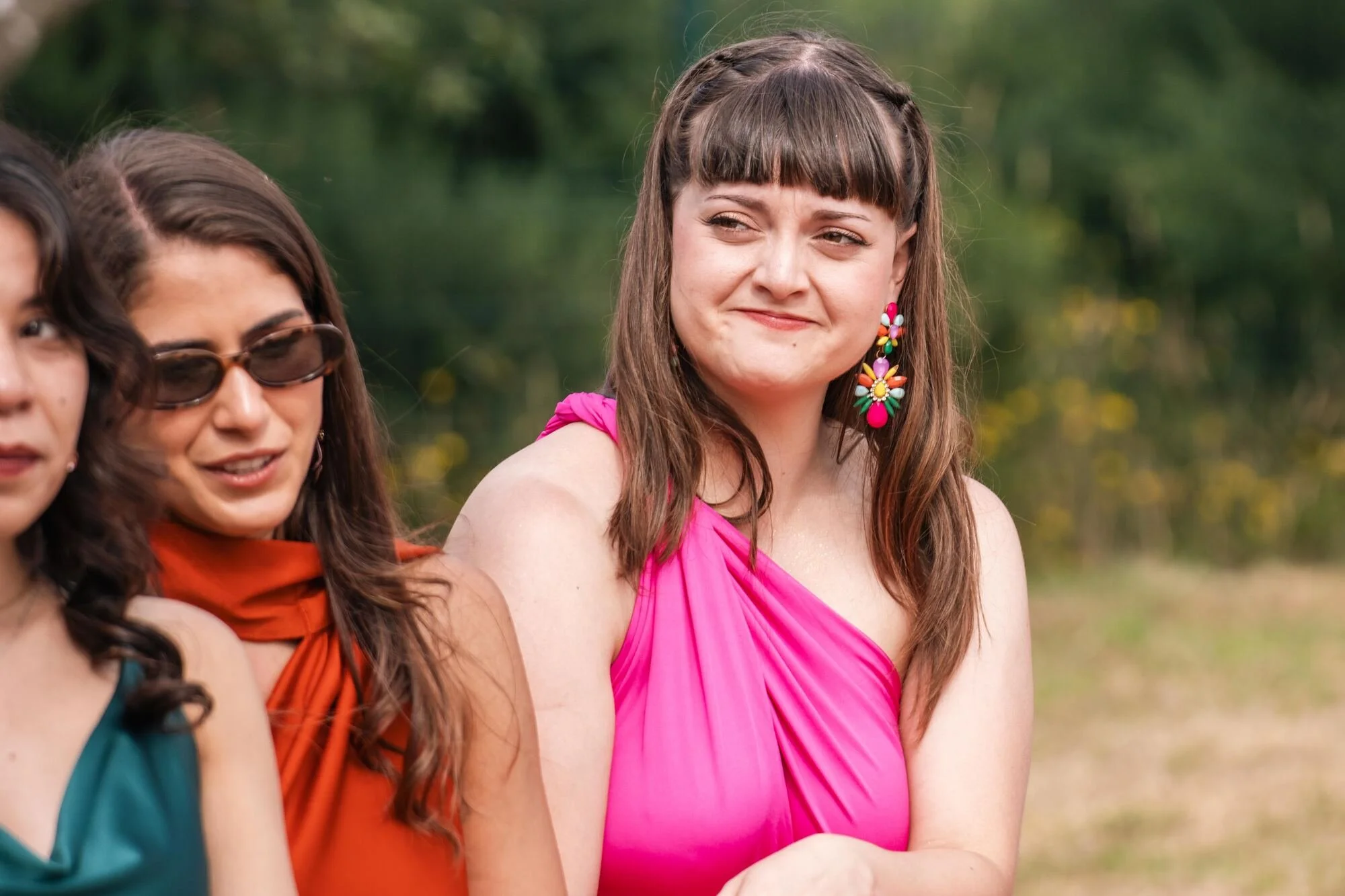 Invitadas siguiendo la ceremonia al aire libre en una boda rústica en Ancud, Chiloé