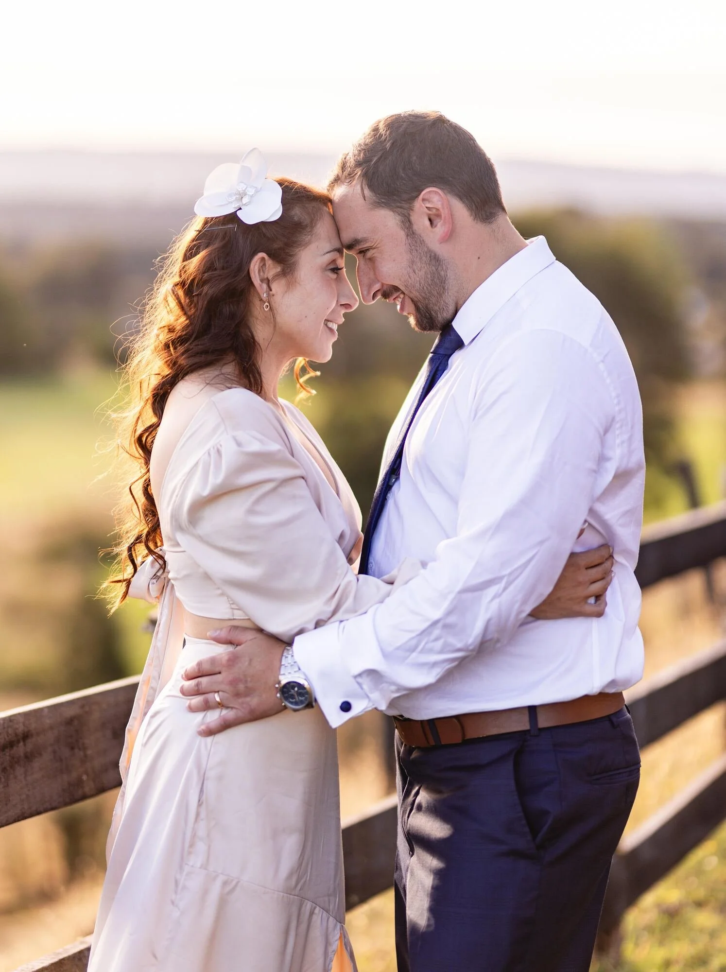 Los novios frente a frente al atardecer con el paisaje de Dalcahue de fondo, Chiloé	