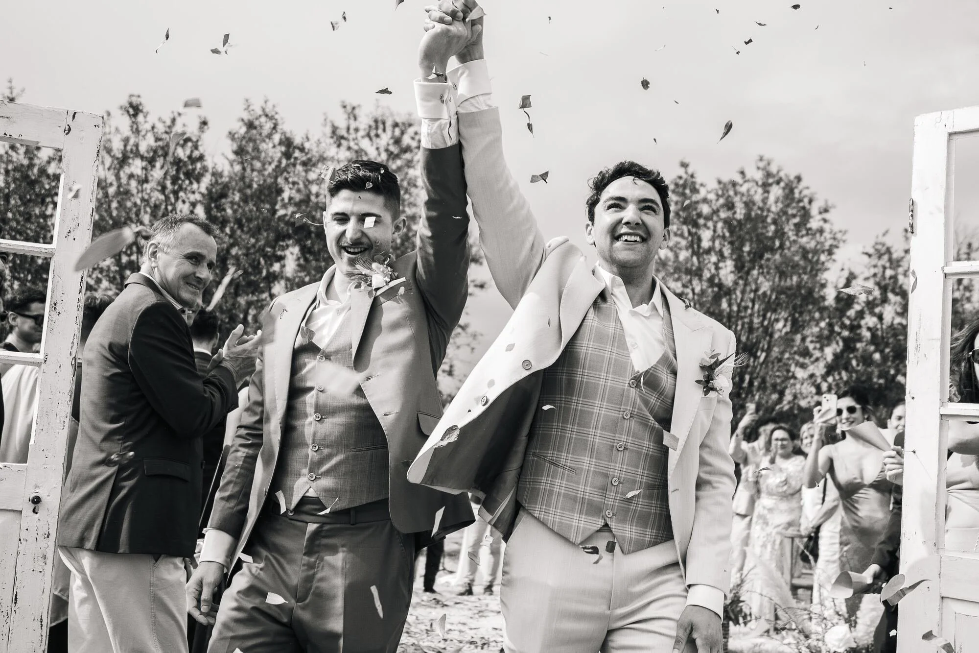 Salida de los novios entre aplausos y pétalos al terminar la ceremonia en Ancud, en blanco y negro