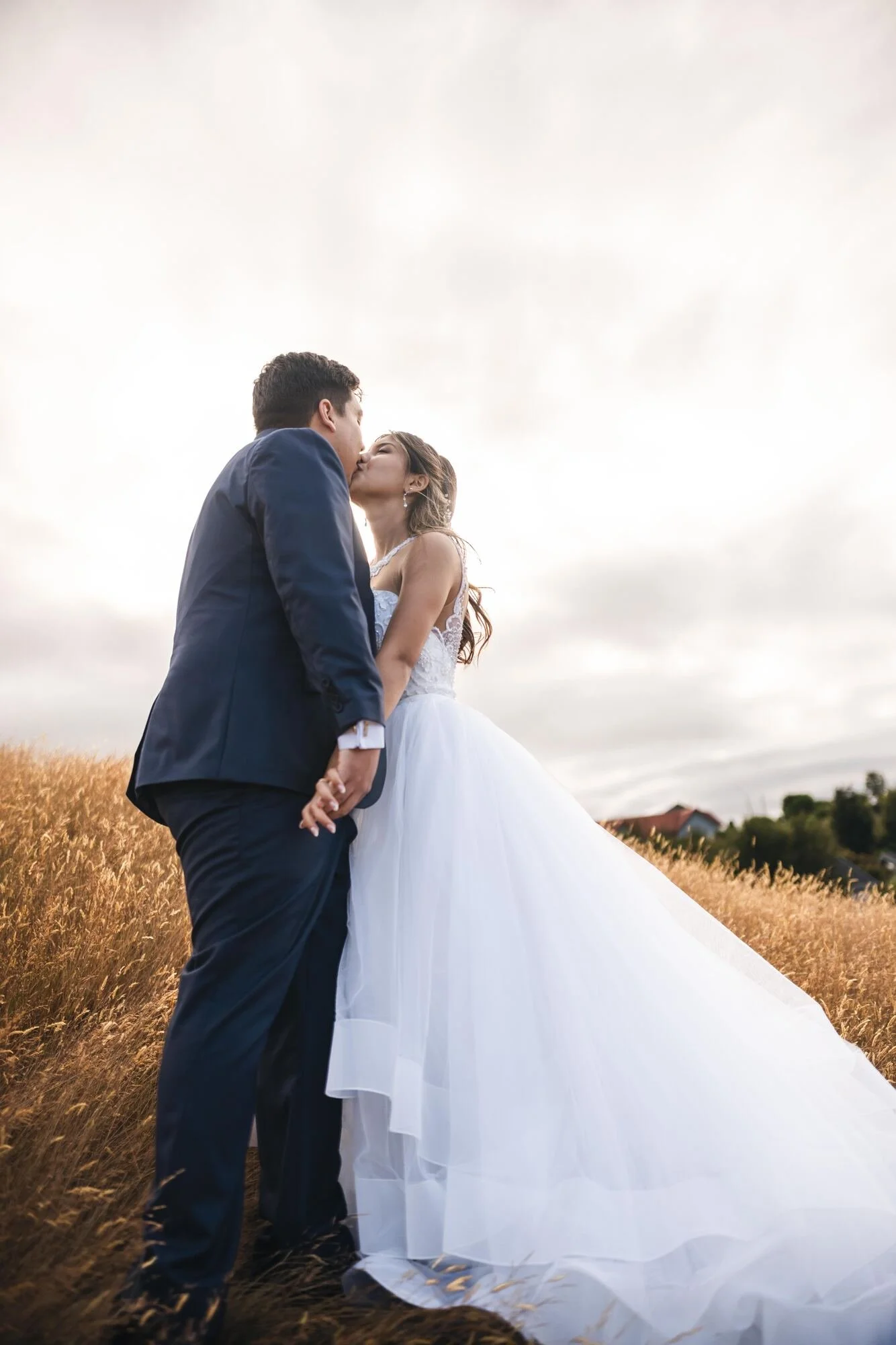 Beso de los novios en el campo al atardecer durante su boda en Castro, Chiloé