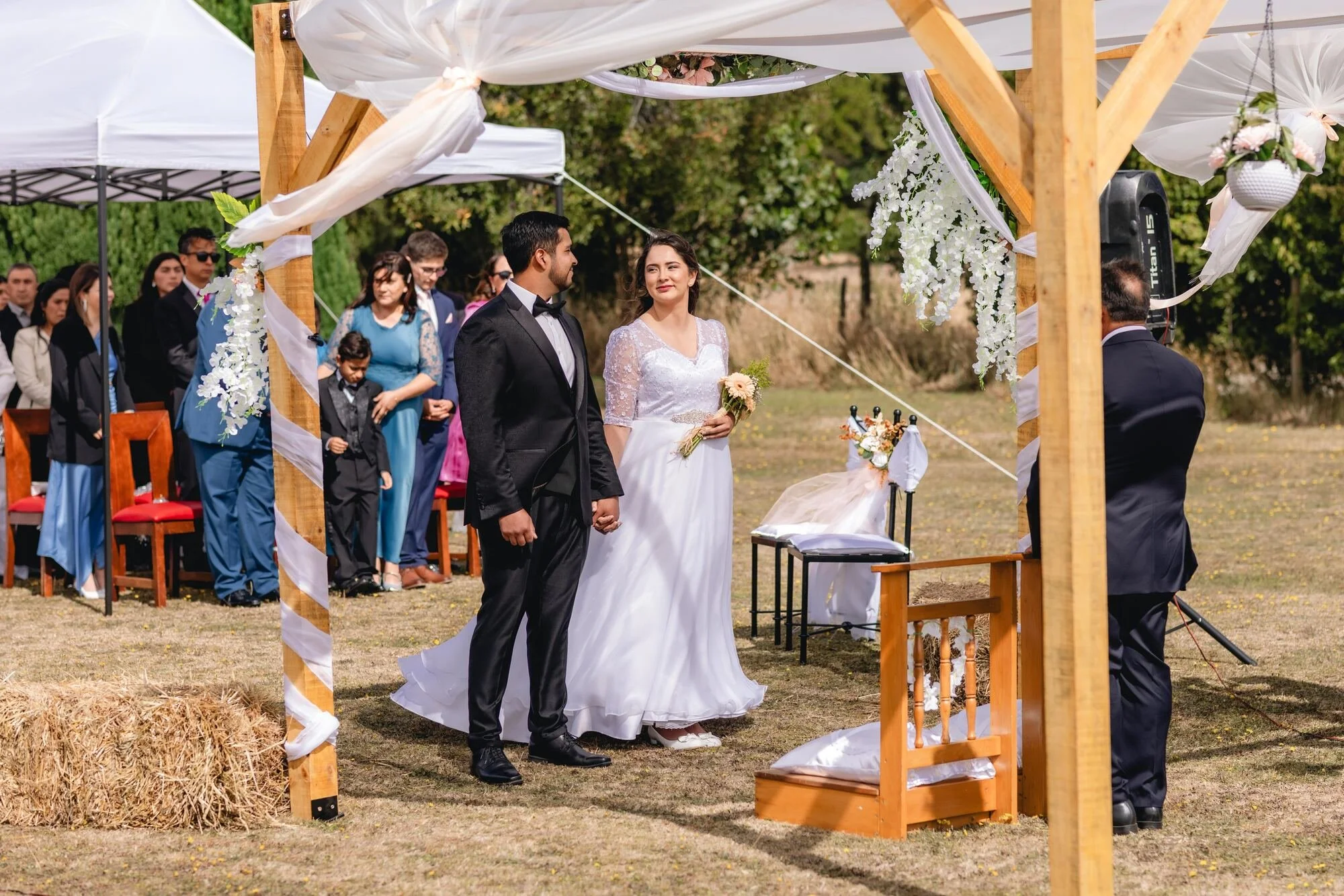 Ceremonia al aire libre con los novios bajo el arco de madera en Quilquico, Castro	