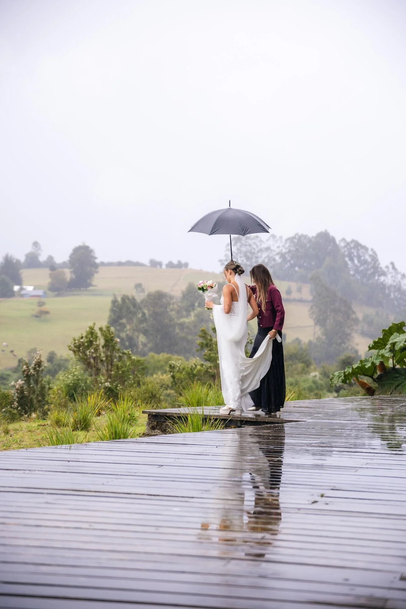 Los novios bajo un paraguas en la pasarela un día de lluvia, Refugia, Castro, Chiloé