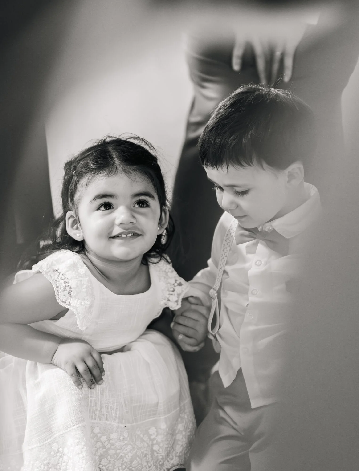 Niños de las arras tomados de la mano durante la boda en Ancud, Chiloé, en blanco y negro