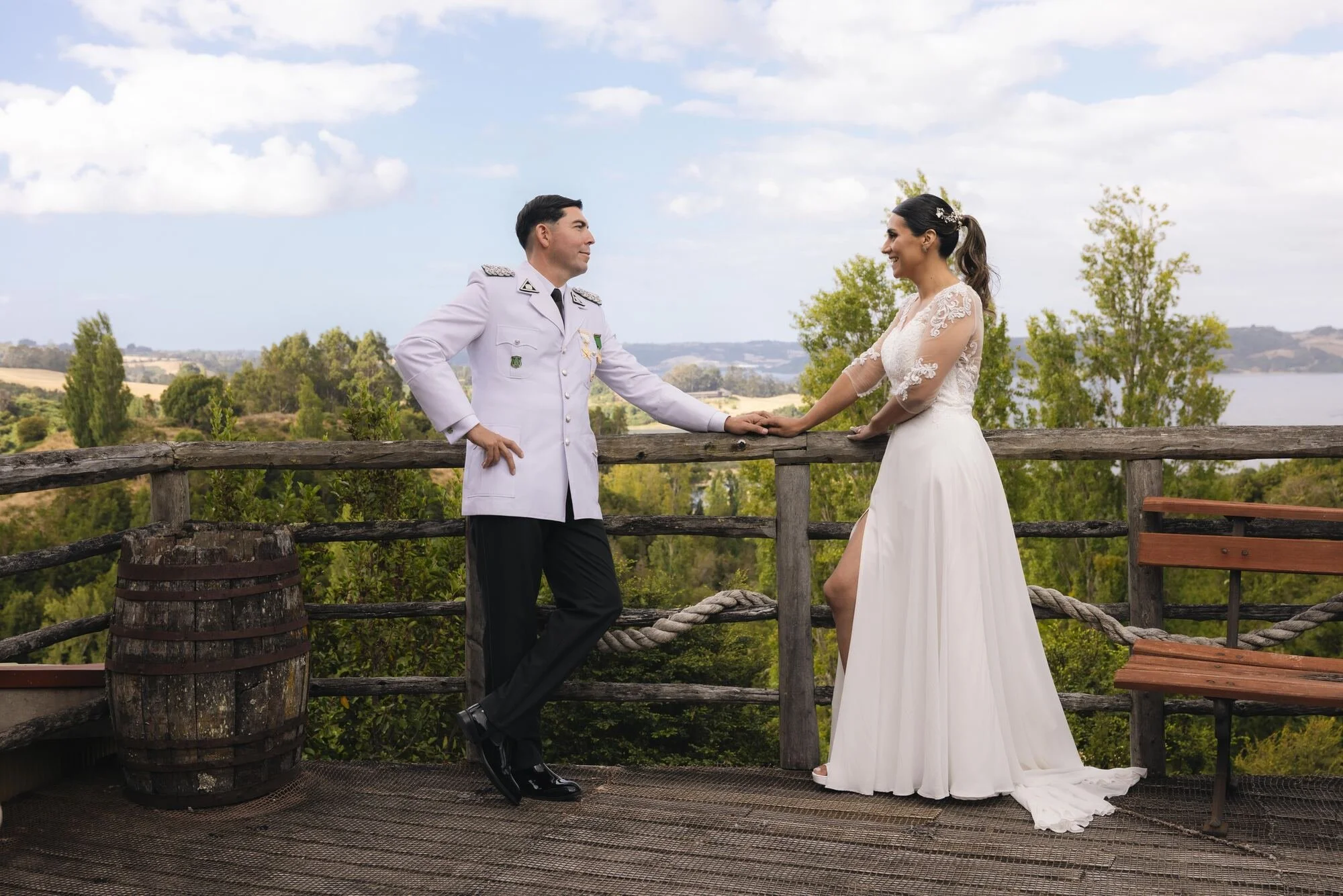 Los novios tomados de la mano en el mirador con vista al paisaje de Quilquico, Castro