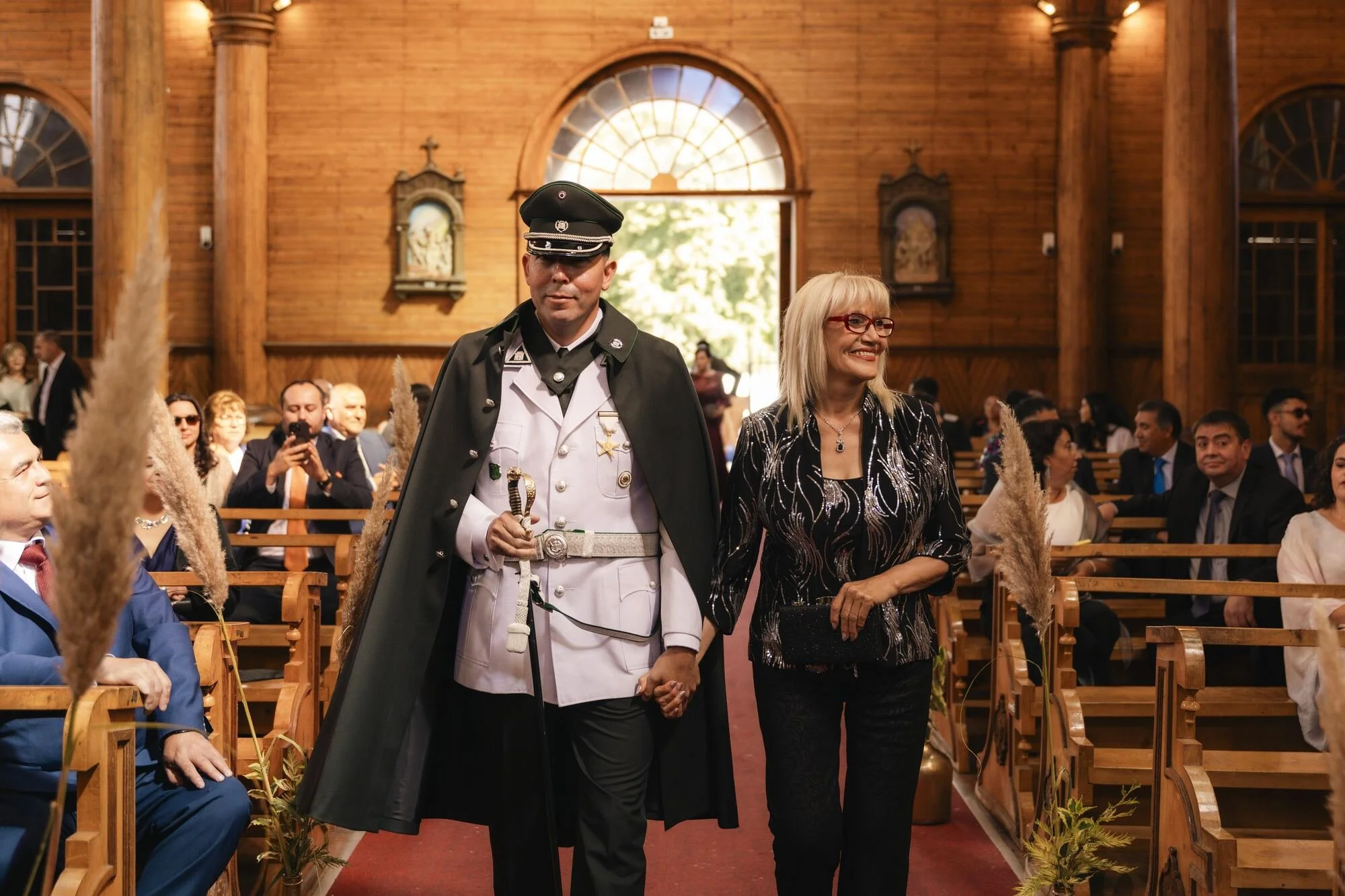 Entrada del novio con uniforme militar acompañado de su madre a la iglesia en Castro