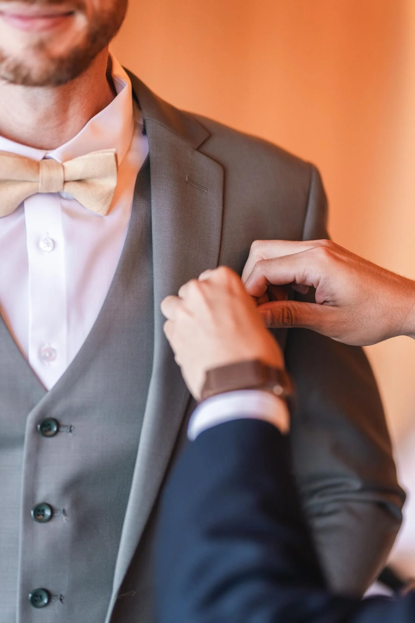 Un amigo ayuda al novio a vestirse durante los preparativos en Refugia, Castro