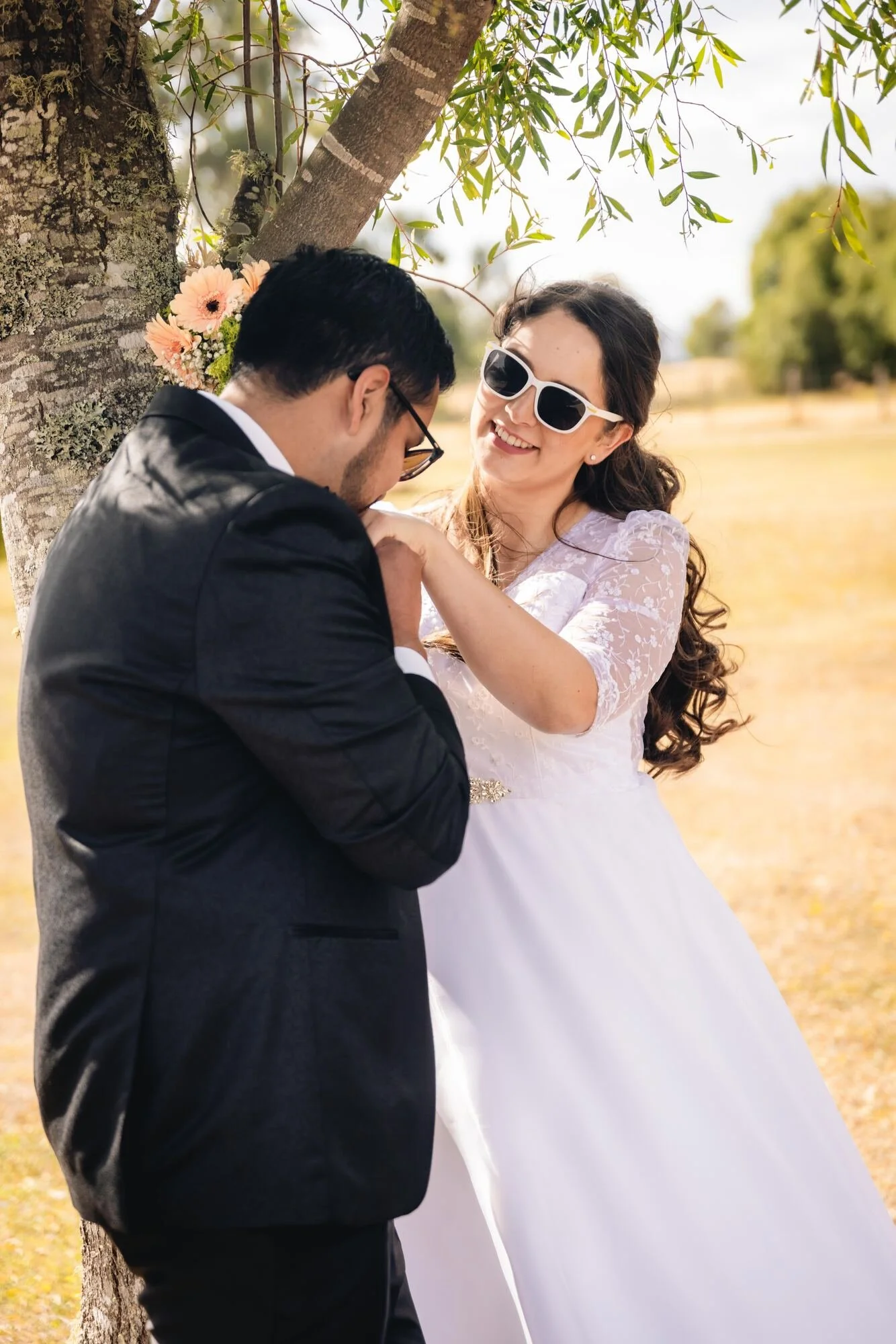 Los novios posando divertidos con lentes de sol bajo un árbol, Quilquico, Chiloé	