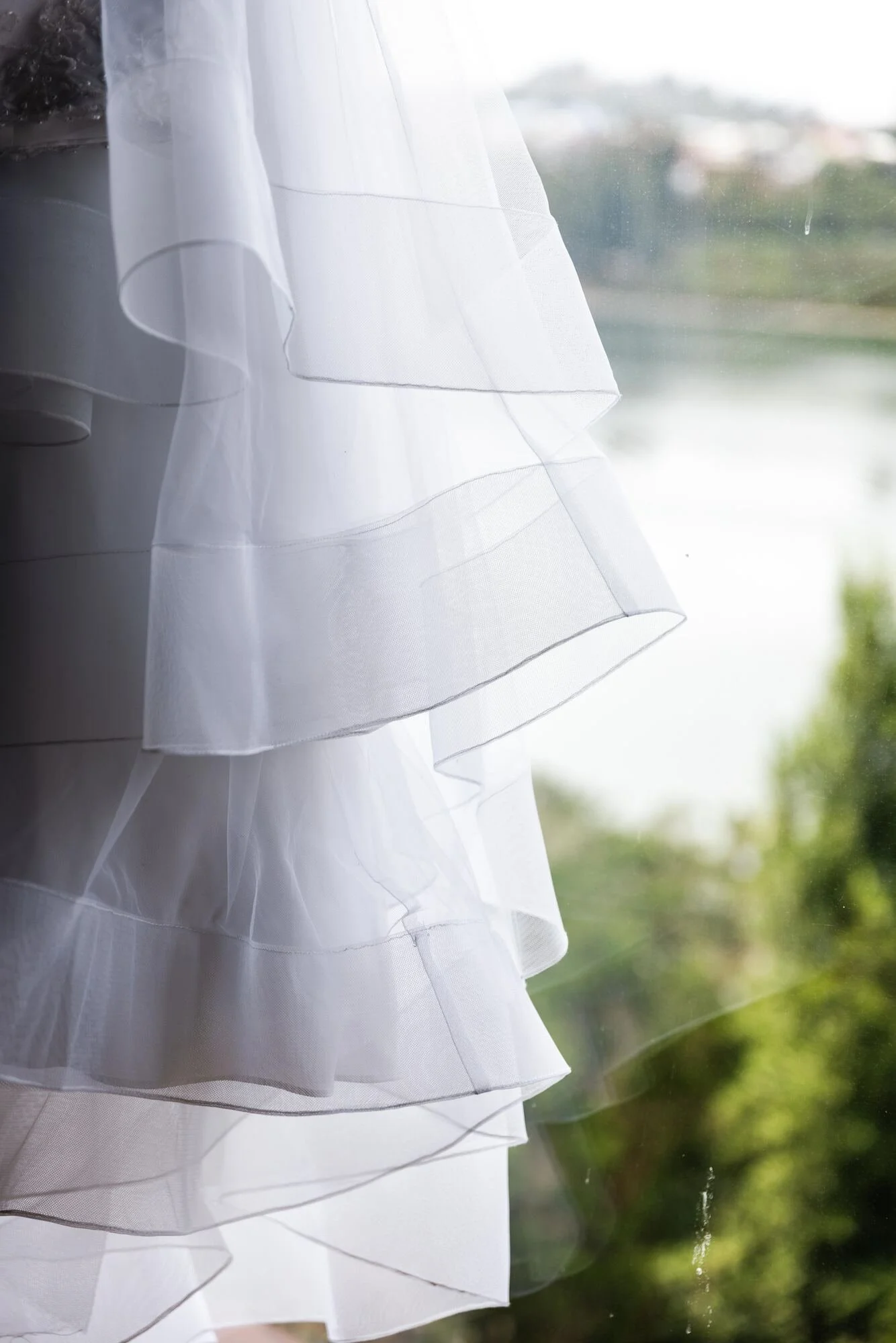 Detalle de los vuelos de tul del vestido de la novia con el paisaje de fondo, Castro, Chiloé	