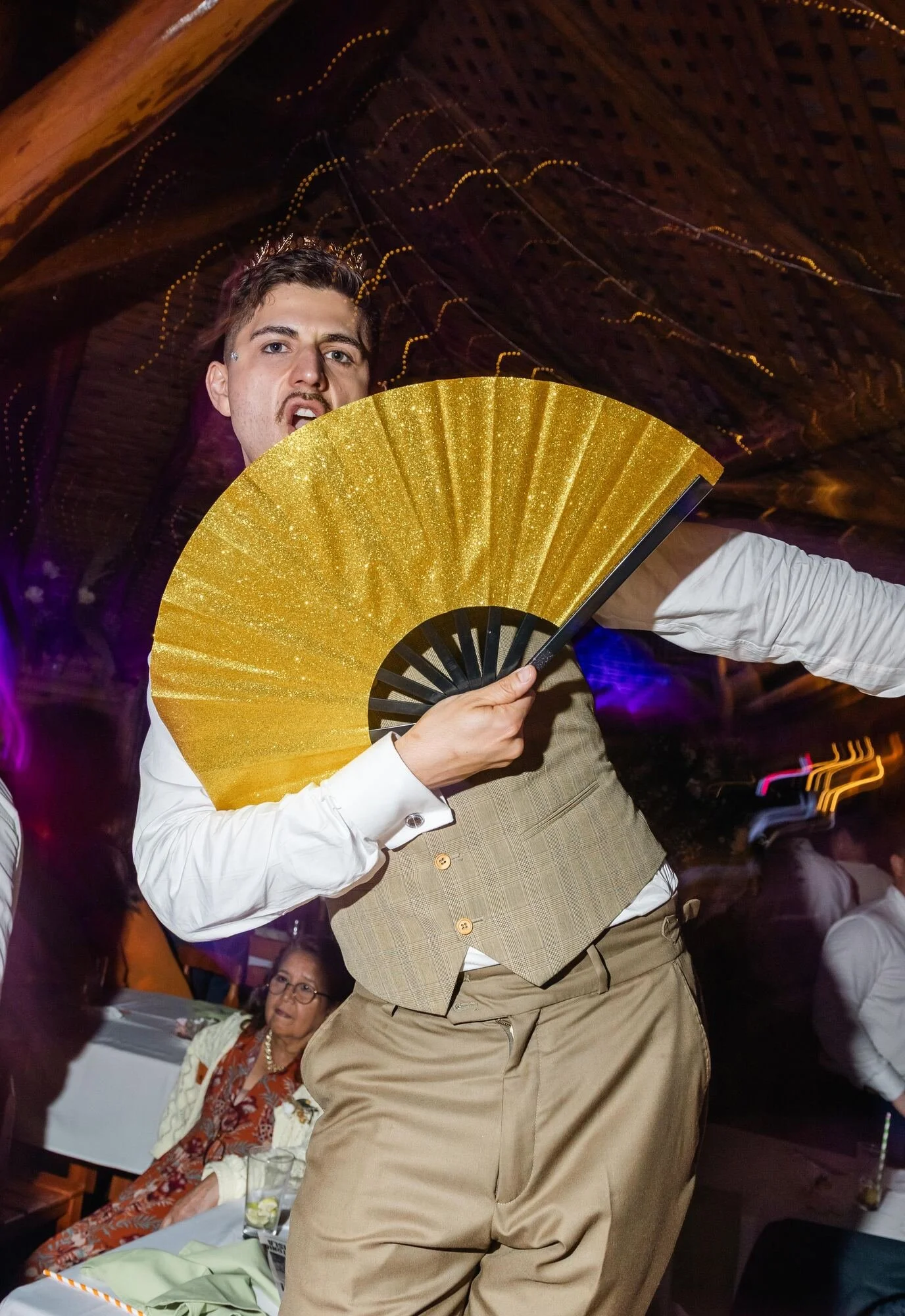 Novio bailando con abanico dorado en la pista de la fiesta de boda en Ancud, Chiloé