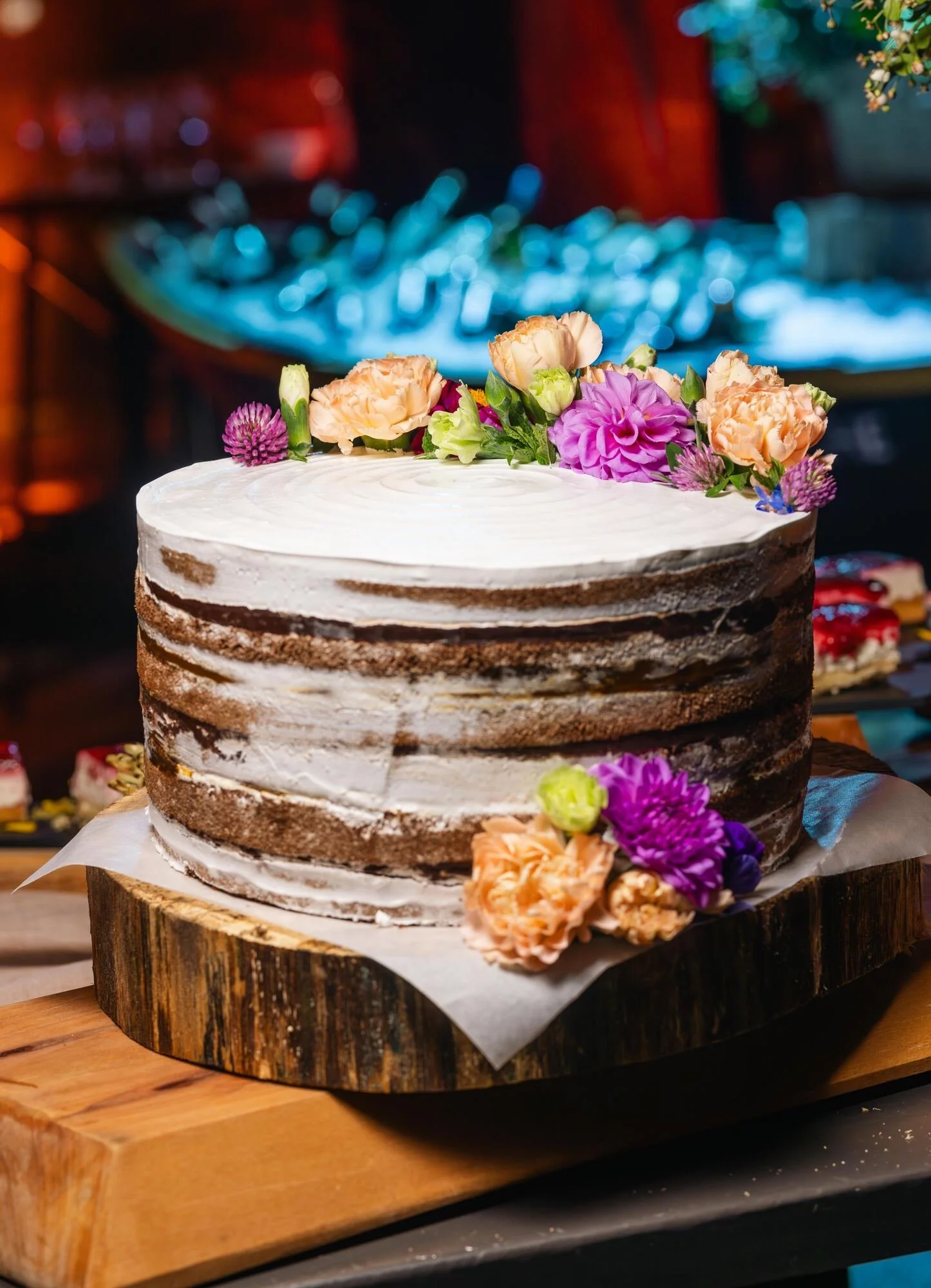 Torta de matrimonio decorada con flores sobre base de madera, Refugia, Castro
