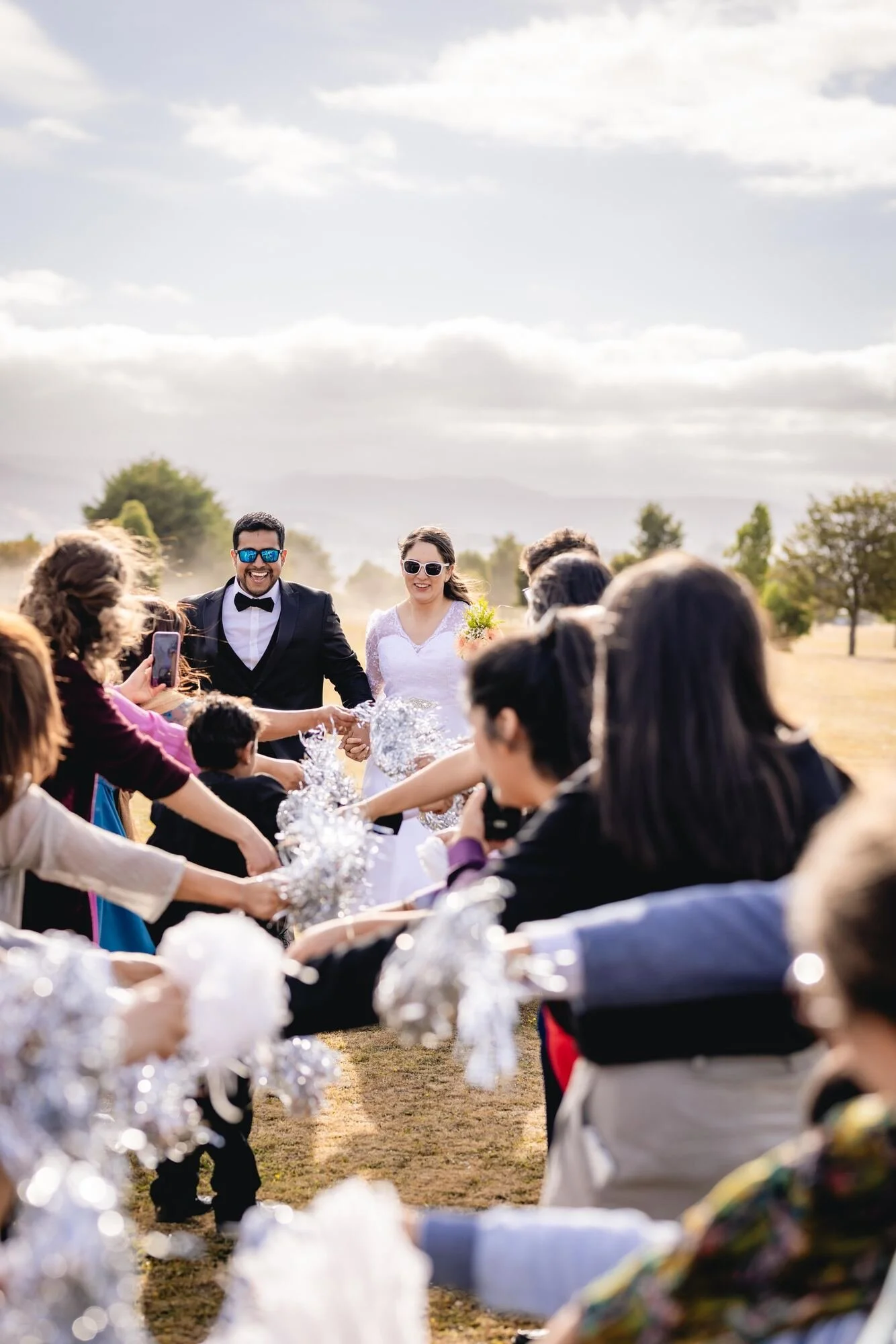 Los novios cruzan la calle de honor formada por los invitados con pompones, Quilquico	