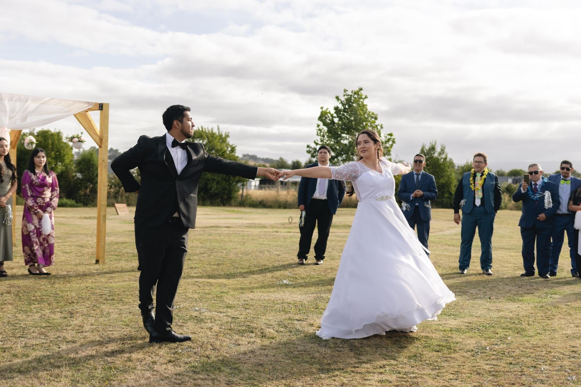 Los novios bailando rodeados de invitados en la celebración campestre en Quilquico	