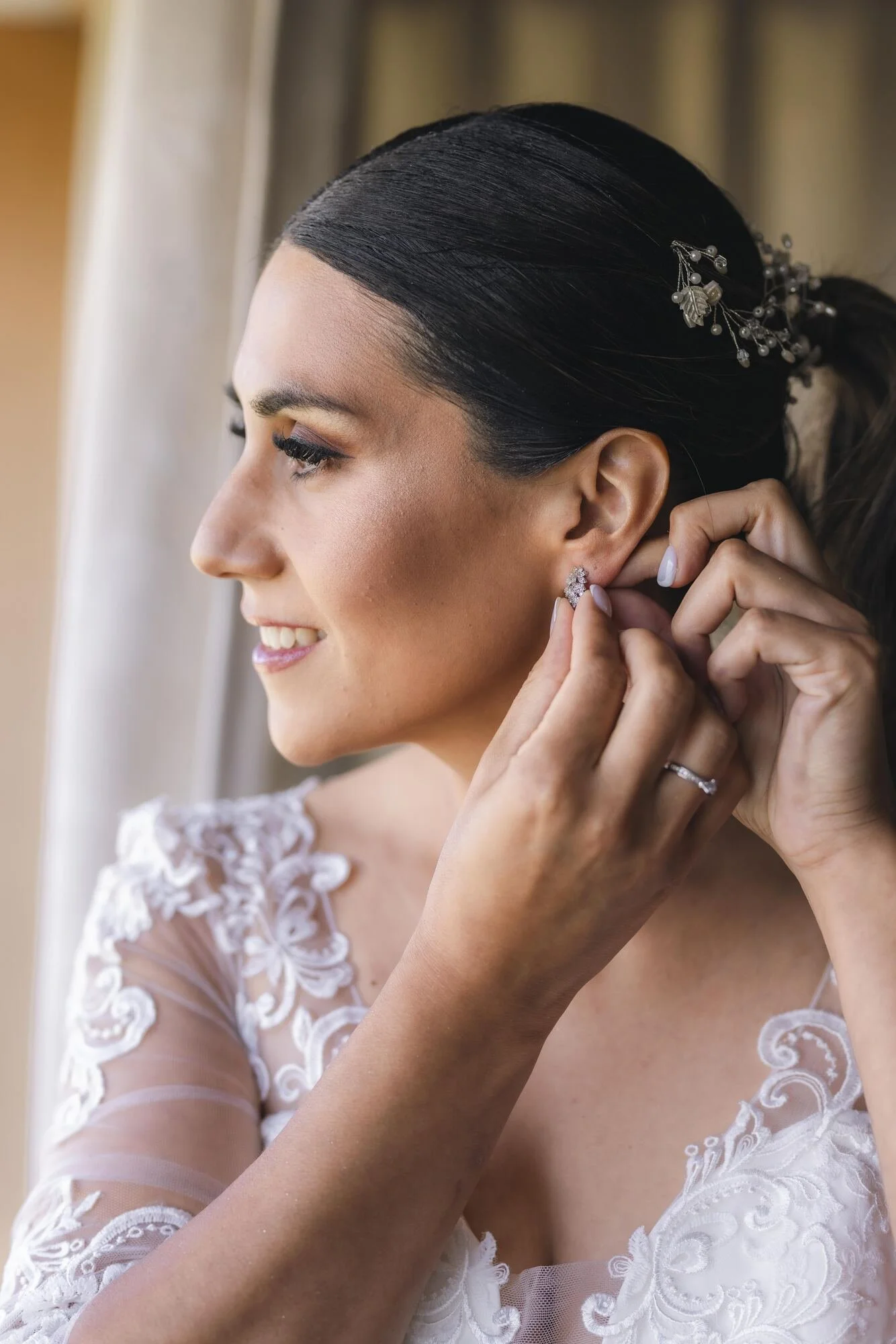 La novia poniéndose los aros frente al espejo durante los preparativos en Chiloé
