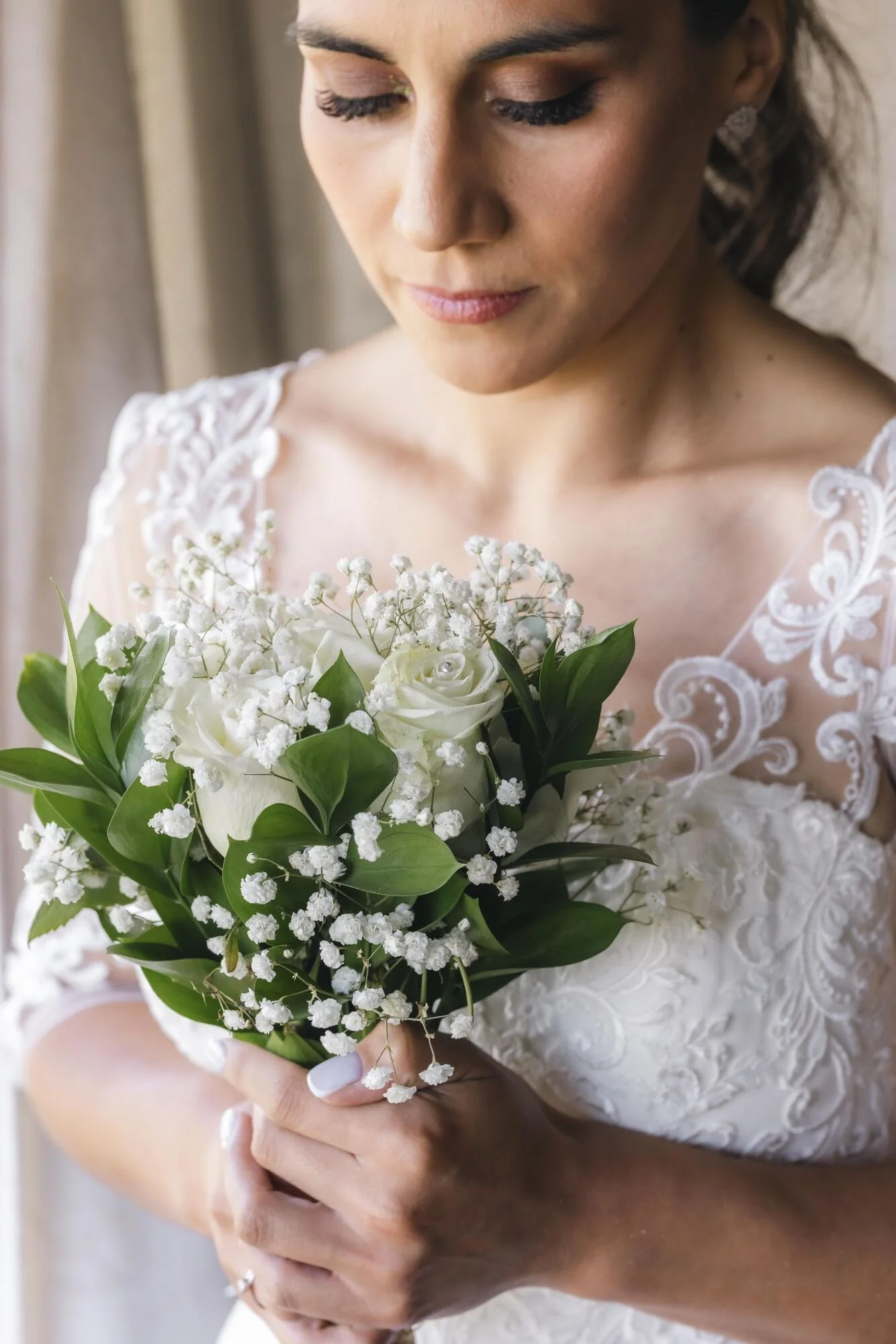 La novia sostiene su ramo de rosas blancas durante los preparativos en Castro, Chiloé