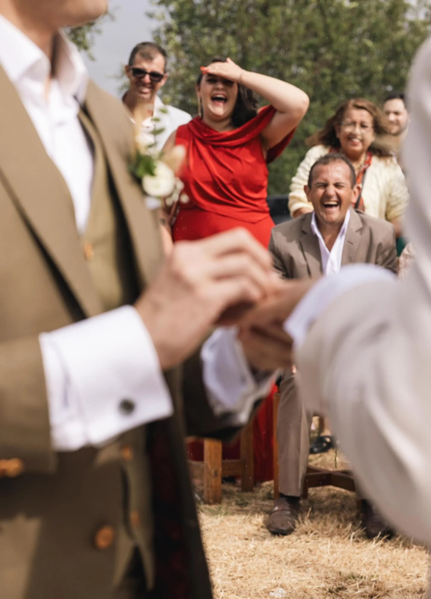 Invitados riendo mientras los novios intercambian los anillos en la boda rústica en Ancud