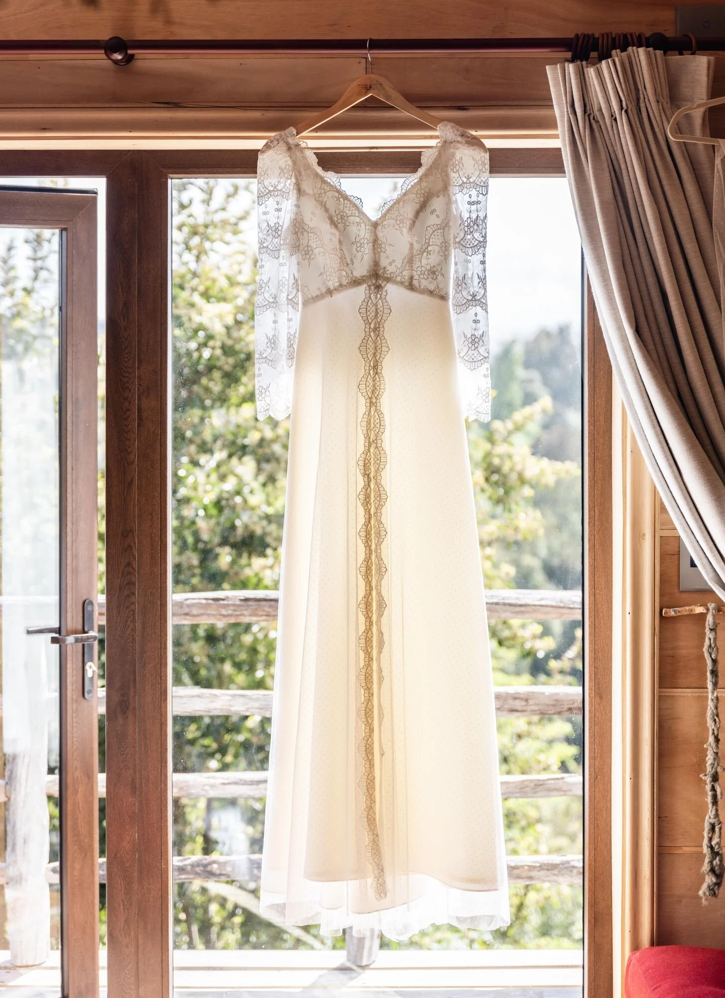 Vestido de novia colgado junto al ventanal del hotel en Quilquico, Castro, Chiloé	