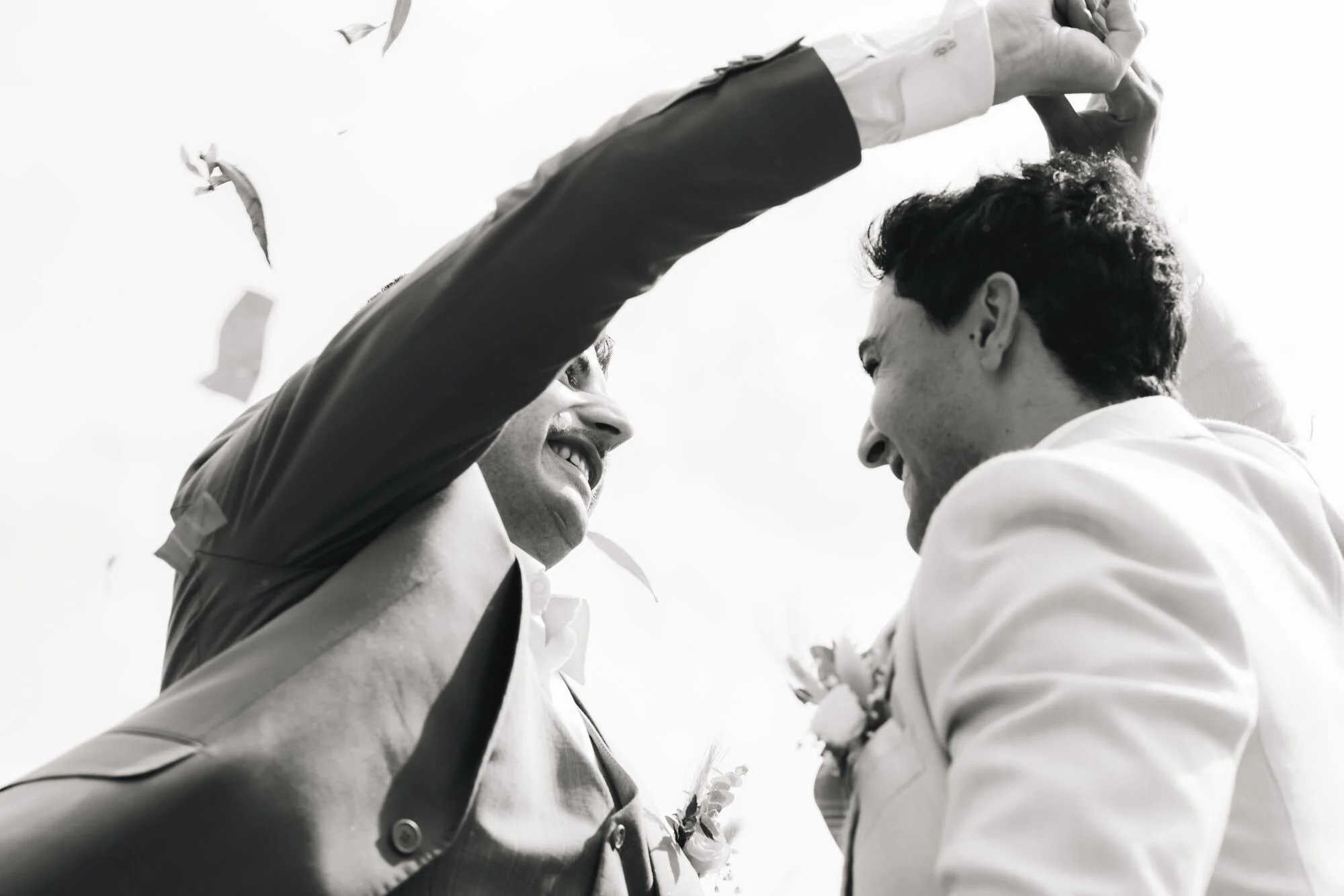 Los novios celebran bajo una lluvia de pétalos, fotografía en blanco y negro de una boda en Chiloé