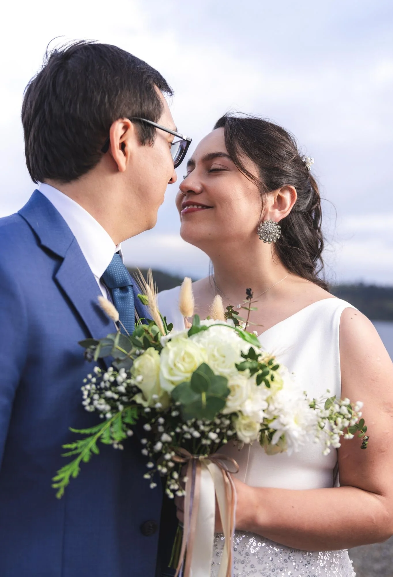 Los novios frente a frente con el ramo de novia en la costa de Castro, Chiloé	