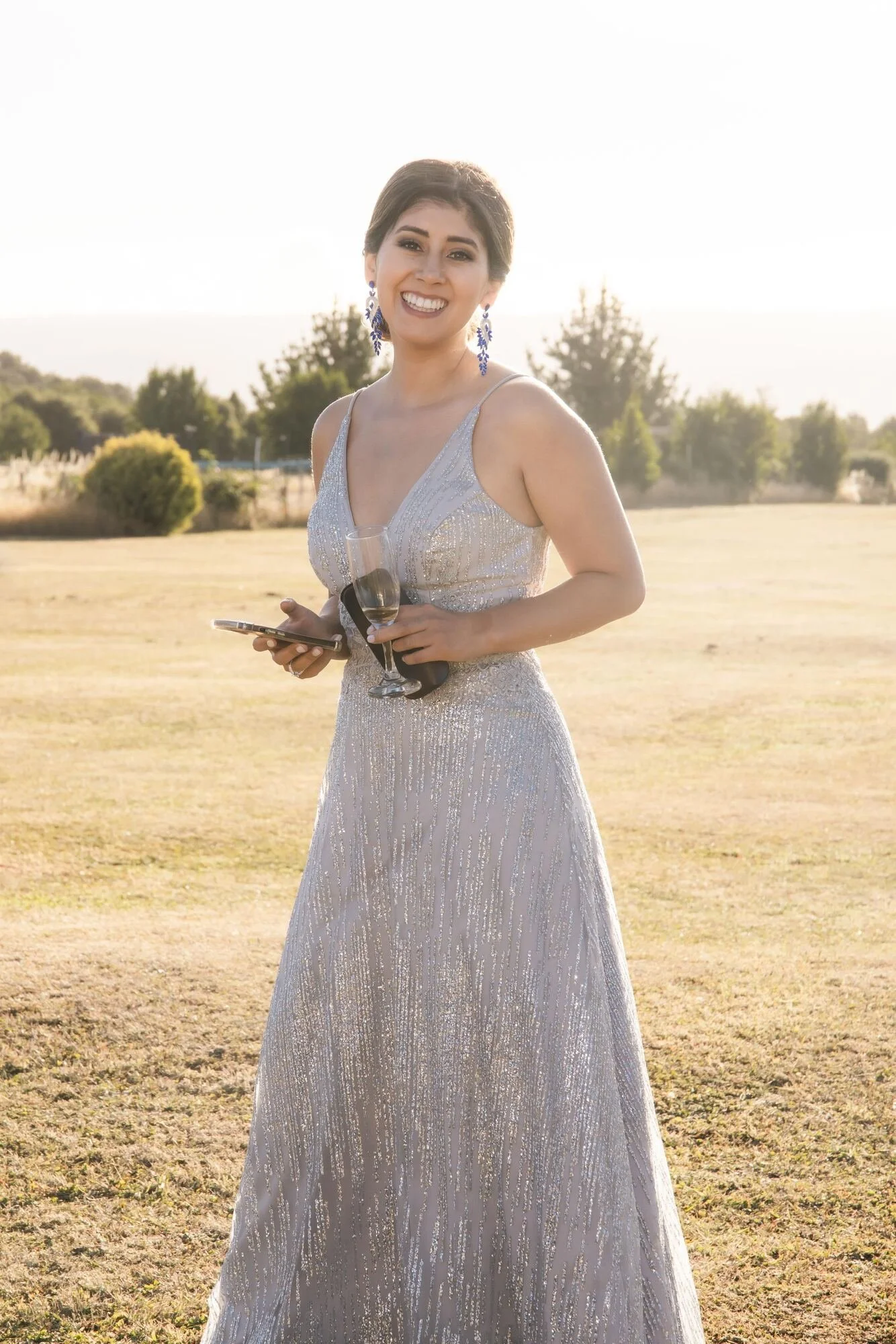 Invitada con vestido plateado durante la recepción al aire libre en Quilquico, Chiloé