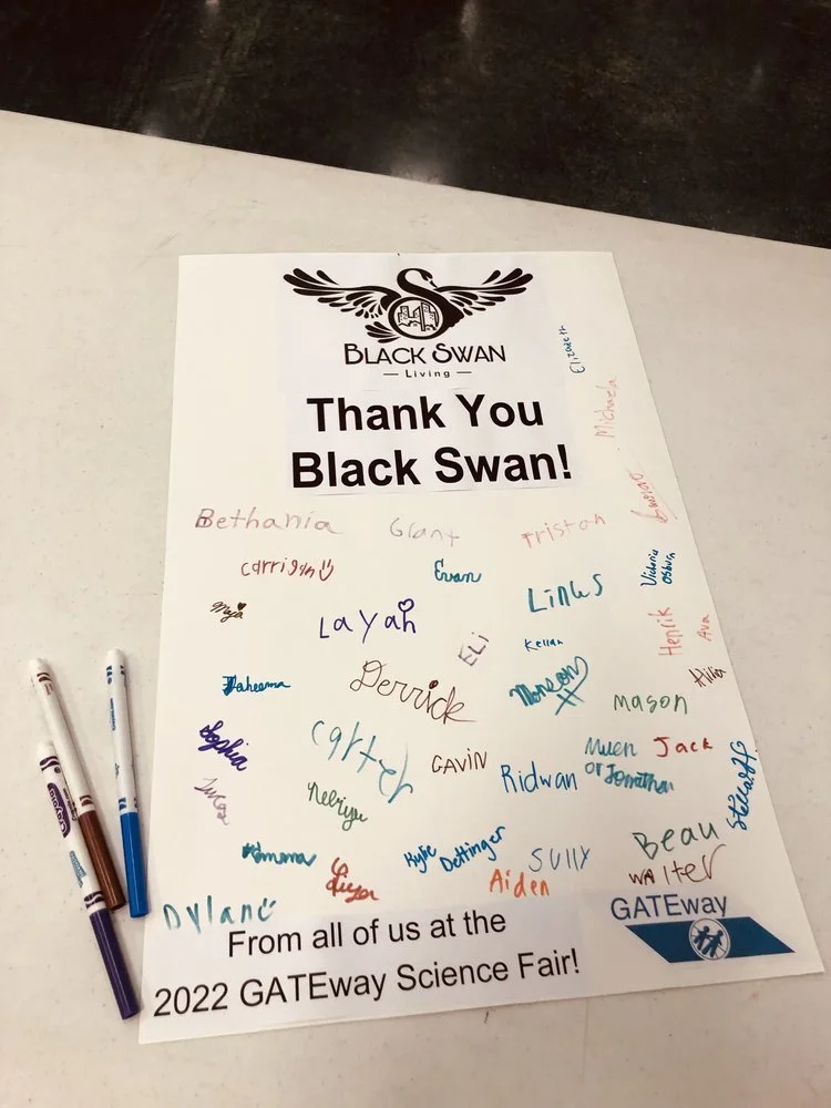 A thank you poster from the 2022 GATEway Science Fair with signatures of participants, and pens beside it.