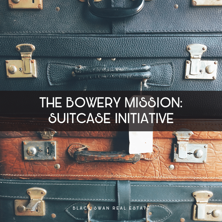Three vintage suitcases stacked on top of each other, each with metal latches and handle, in black, brown, and dark green colors.