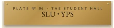Gold plaque with black text reading 'Plate No 04. The Student Hall SLU YPS'