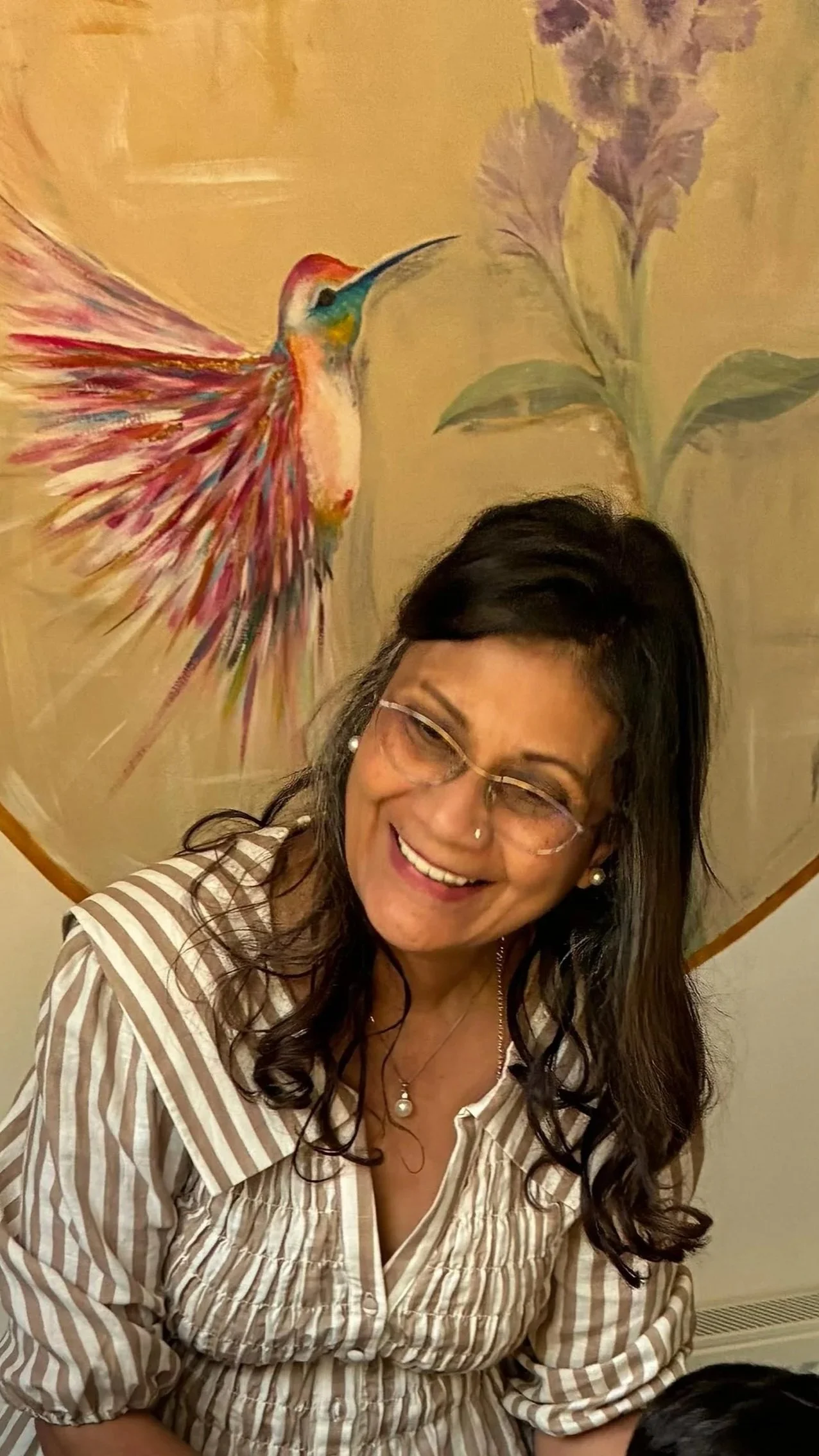 A woman with a mural behind her