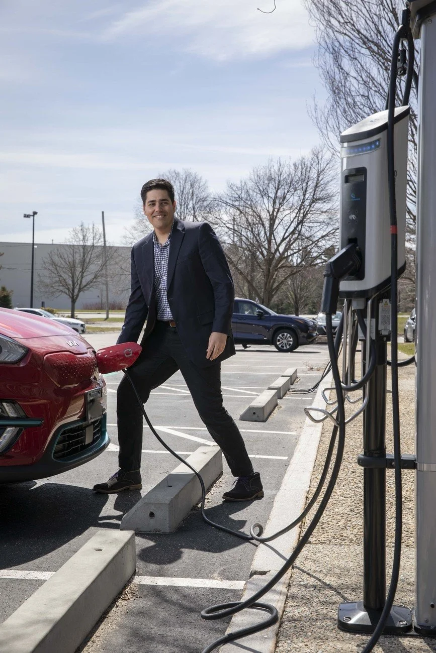 Man in business suit charging EV
A professional charging an electric vehicle at an outdoor charging station, illustrating the growth of EV infrastructure.