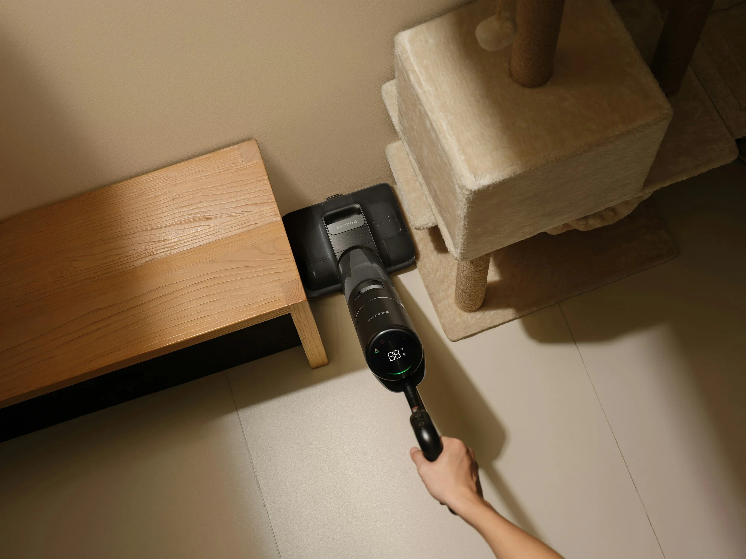 Person vacuuming carpeted furniture with a handheld vacuum cleaner.