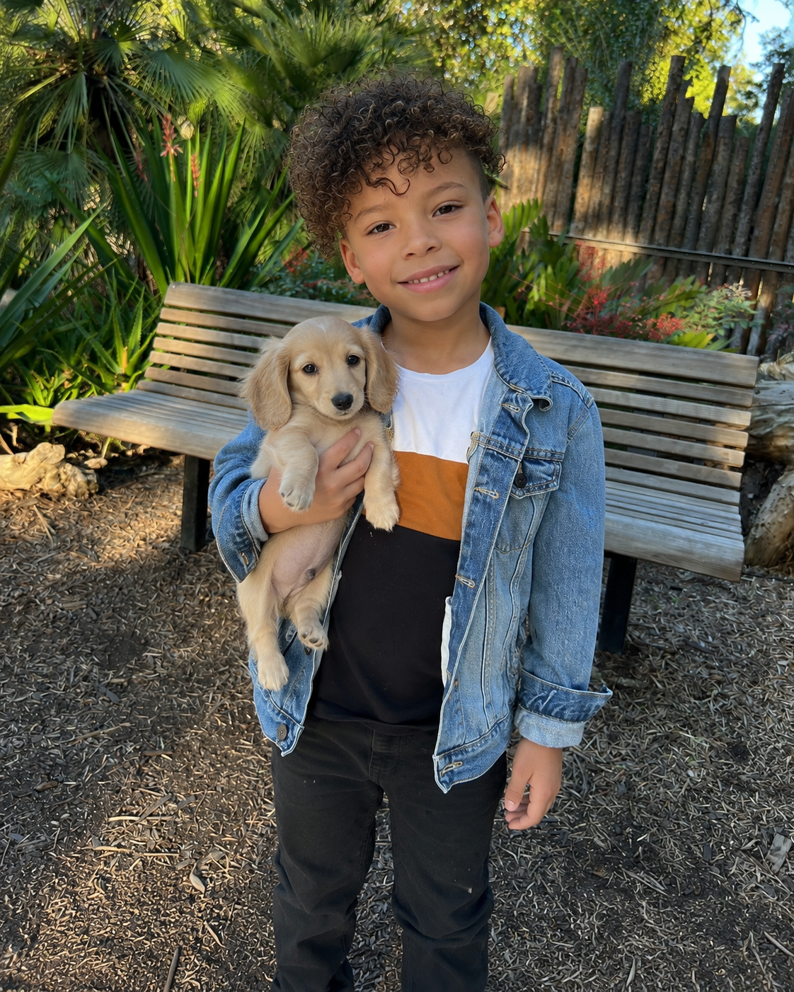 Picture of Aidan, holding puppy outside of home after drop off.