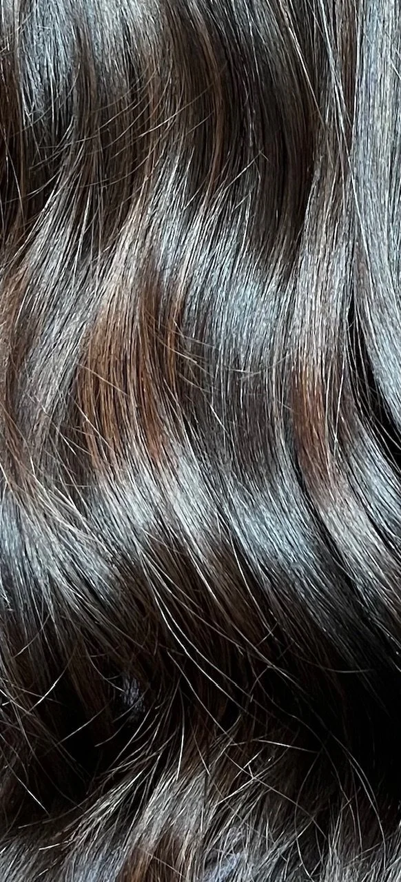 Close-up of wavy brown hair with shiny strands.