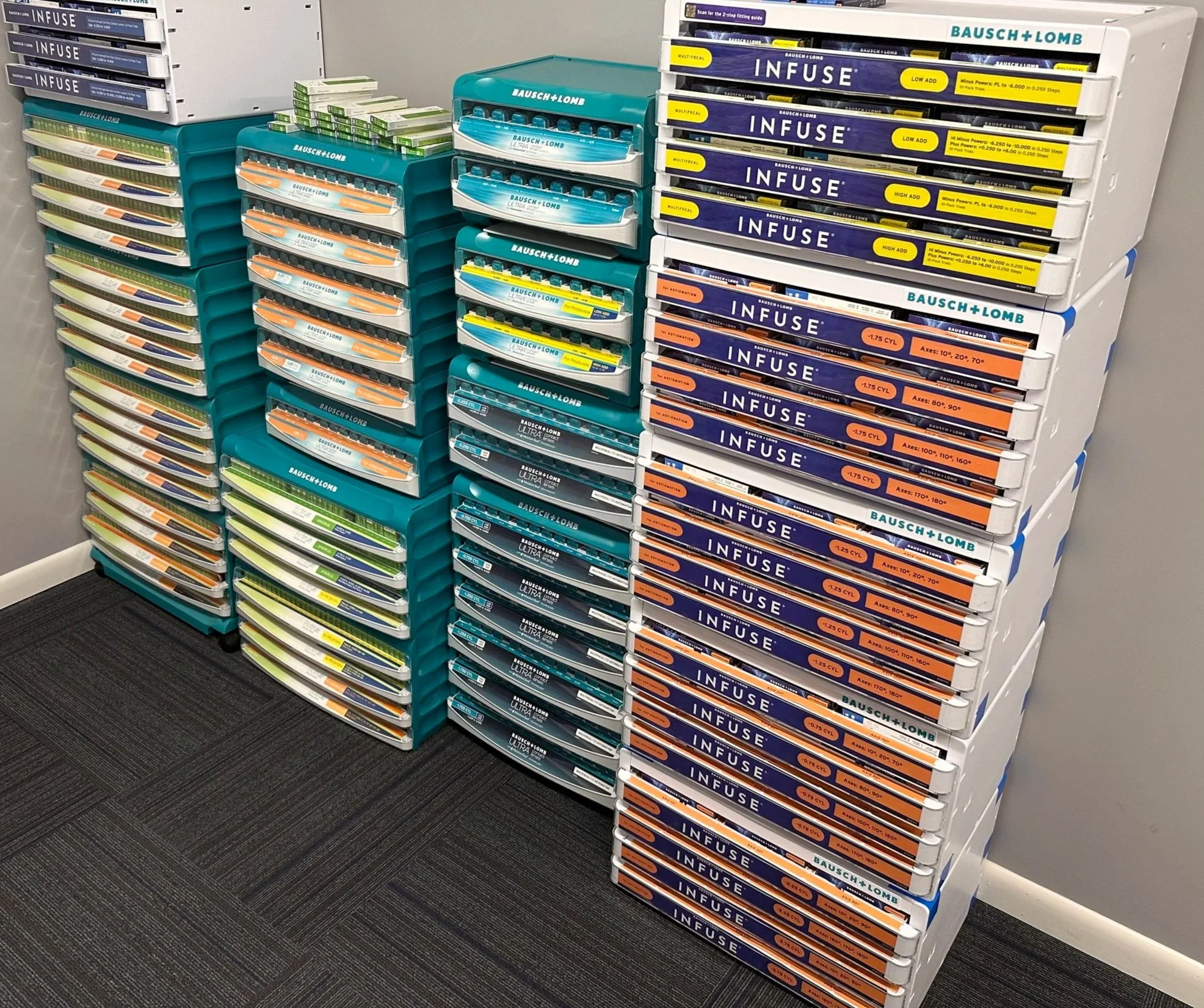 Display of contact lenses boxes on shelves in a store, with various brands such as Bausch + Lomb and Infuse.