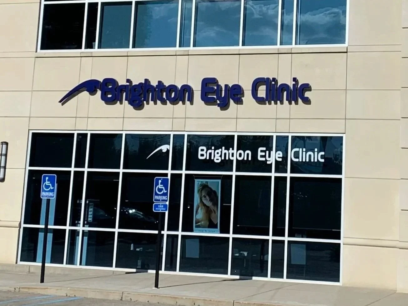 The exterior of Brighton Eye Clinic with large glass windows, two wheelchair accessible parking signs, and signage displaying the clinic's name.