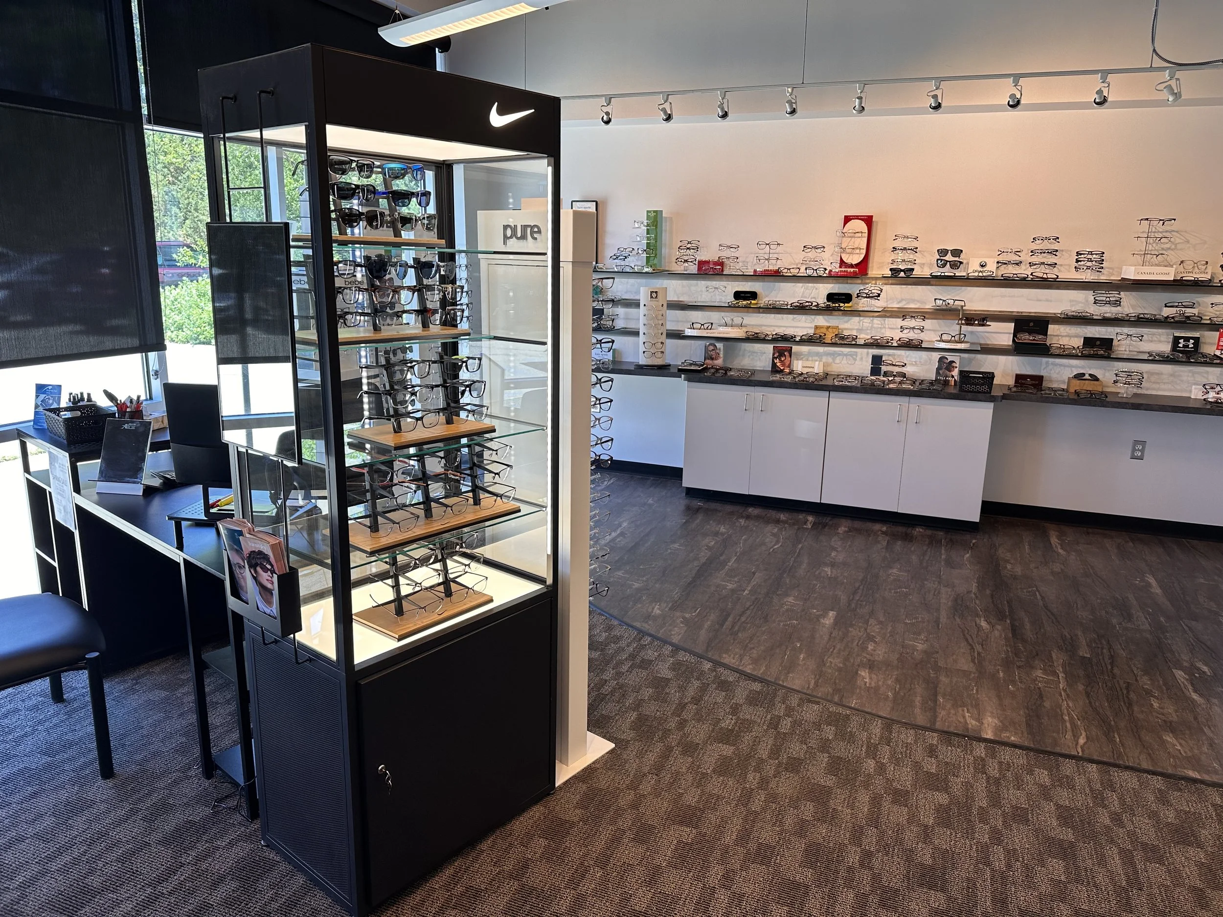 Inside an eyewear store with glasses displayed on shelves and a Nike sign displayed on a black display case.