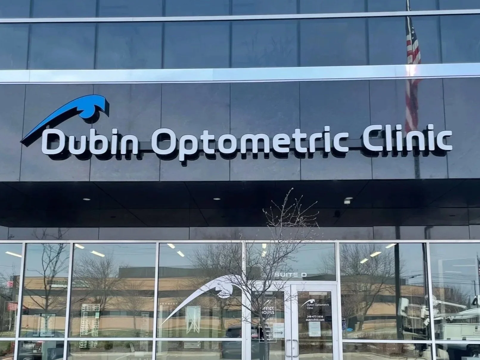 Sign on a building that reads 'Dubin Optometric Clinic' with a logo of an eye.