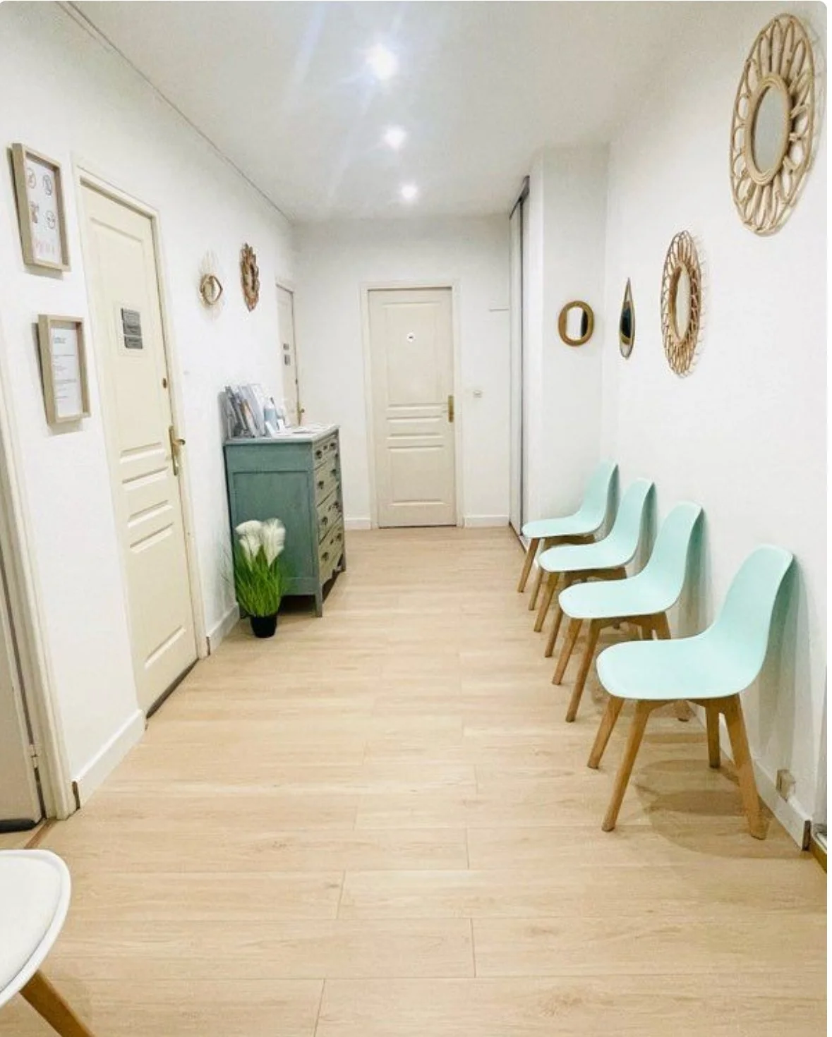 Salle d'attente d'un cabinet de psychologie à Nice, avec cinq chaises vertes alignées le long du mur blanc.