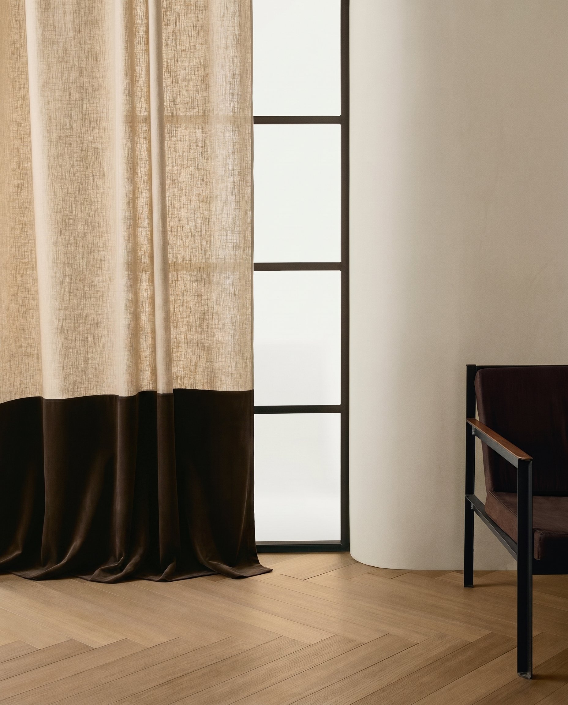 Ein Vorhang, eine Glastür mit schwarzen Rahmen, eine weiße Wand und ein Stuhl an einem Tisch. Designer Call bei Jeseva Interior Design
