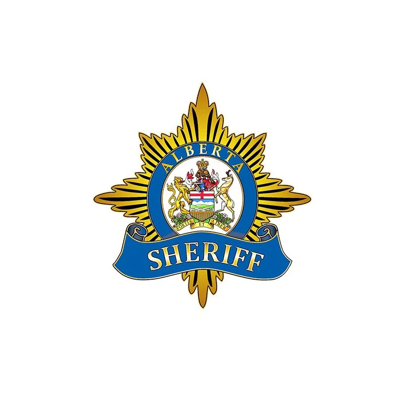 Sheriff badge with the word 'Sheriff' and the word 'Alberta' at the top, featuring a coat of arms with a shield, animals, and a banner.