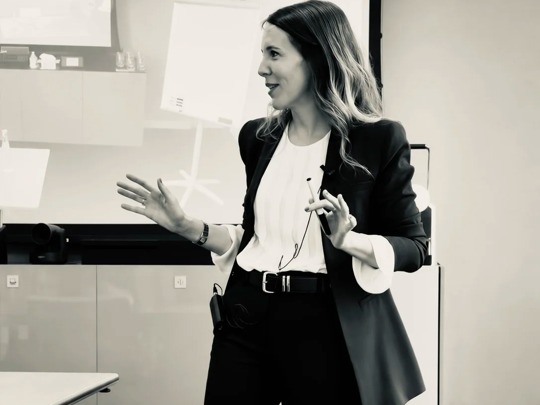 Mujer de negocios dando una charla o presentación en una oficina.