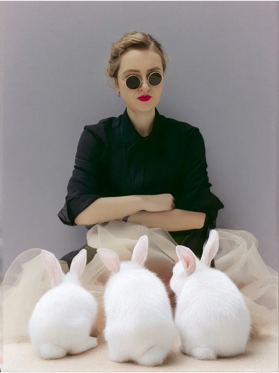 Professional portrait of artist Aleksandra Ola wearing sunglasses and holding white rabbits, featured on the about page of her gouache painting portfolio.