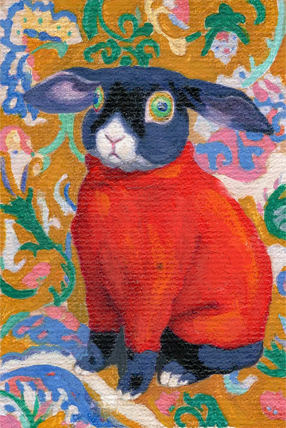 A colorful miniature painting of a black and white rabbit wearing a red garment. The background features intricate floral patterns in pink, blue, green, and white on a gold-colored surface.