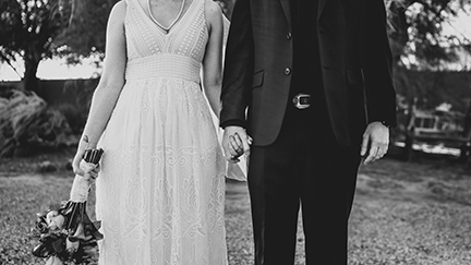 bride and groom holding hands in country setting