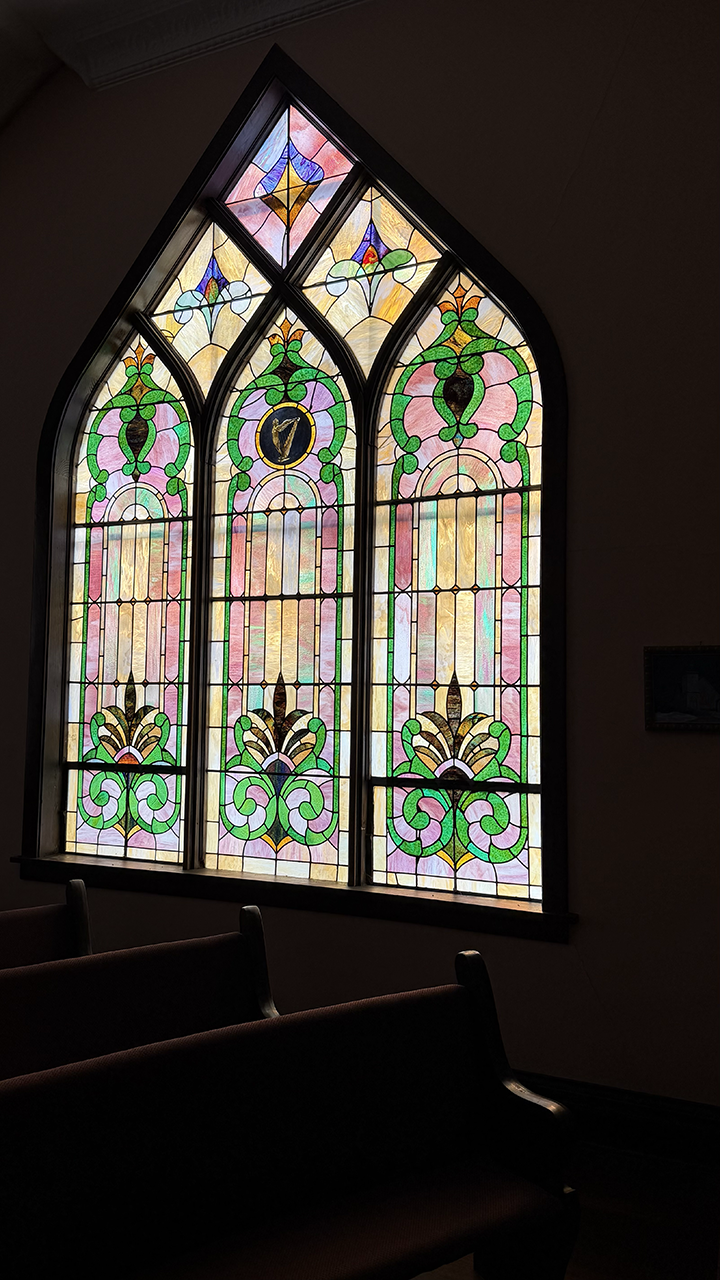 Stained glass window glowing in evening light at Pleasant Valley Country Church